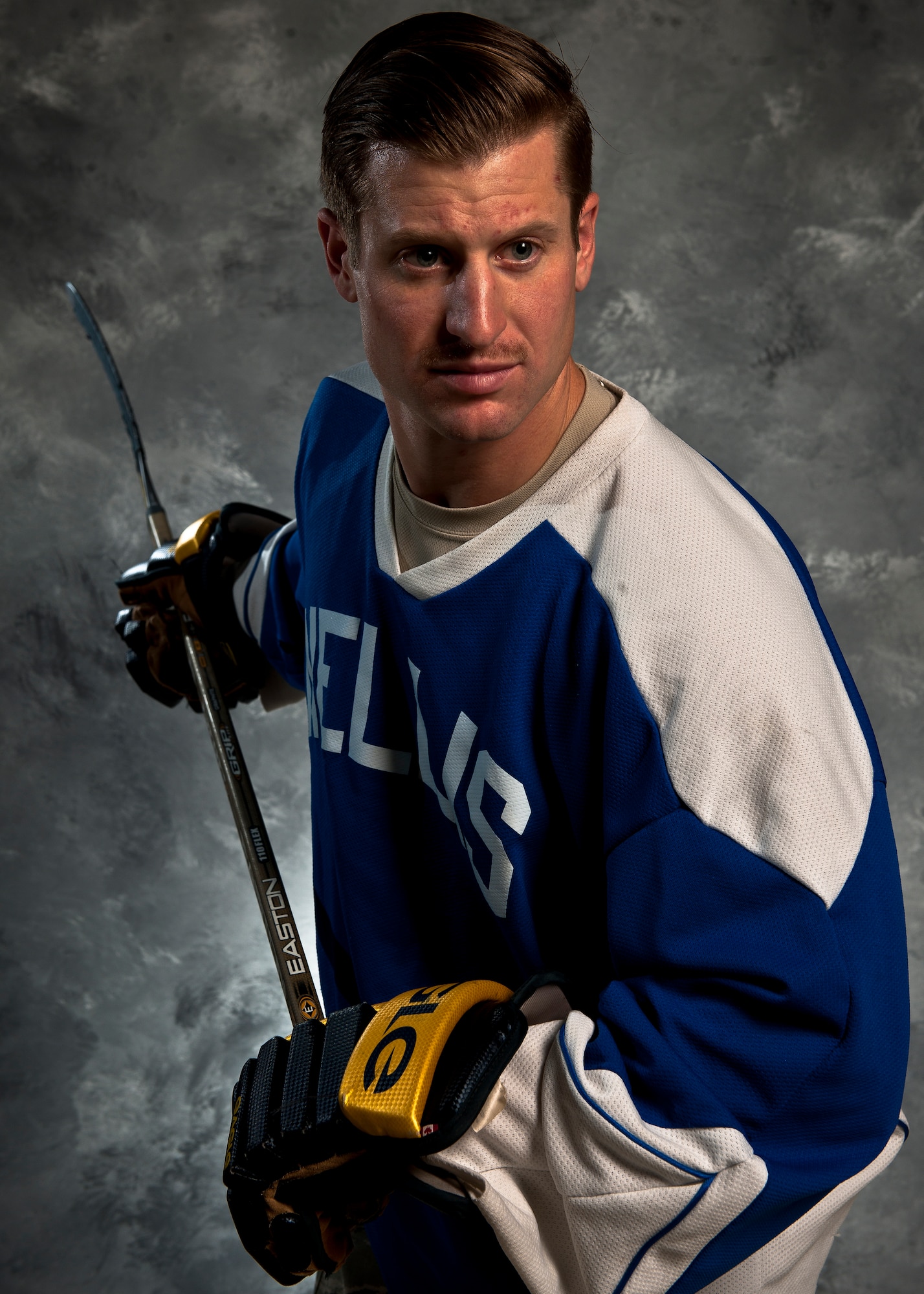 Johnny Lupo, a member of two Las Vegas-area hockey teams, poses for a photo at Nellis Air Force Base, Nev., Nov. 5, 2014. After graduating from high school, Lupo, a native of Wallingford, Conn., almost chose to chase his dream of playing professionally, but instead attended Norwich University, Vt., and become a commissioned officer in the U.S. Air Force. Lupo is now a captain and the commander of the 99th Force Support Squadron Military Personnel Flight. (U.S. Air Force photo by Staff Sgt. Siuta B. Ika)