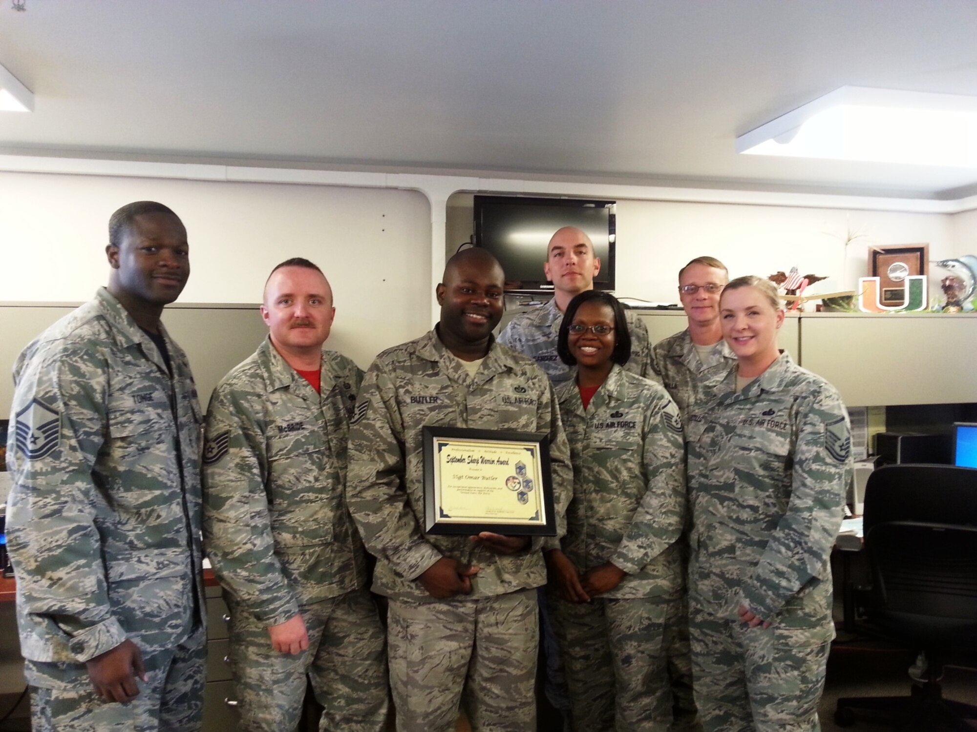 PETERSON AIR FORCE BASE, Colo. – Master Sgt. Chet Tonge and Tech. Sgt. Charles McBride, on behalf of the Pikes Peak Top 3, present Staff Sgt. Omar Butler, 21st Logistics Readiness Squadron, the September 2014 Sharp Warrior Award Oct. 31. Butler resolved a critical situation for a short-notice deployer, getting him the only seat available to arrive by his deployment date, ensuring timely movement to the area of responsibility. Without Butler’s actions, this position would have been vacant for more than a week, negatively impacting intelligence support to special operations in the Central Command theatre. Butler’s dedication and proficiency at his duties, and professionalism on and off duty, led to his selection as the Sharp Warrior. (U.S. Air Force photo)