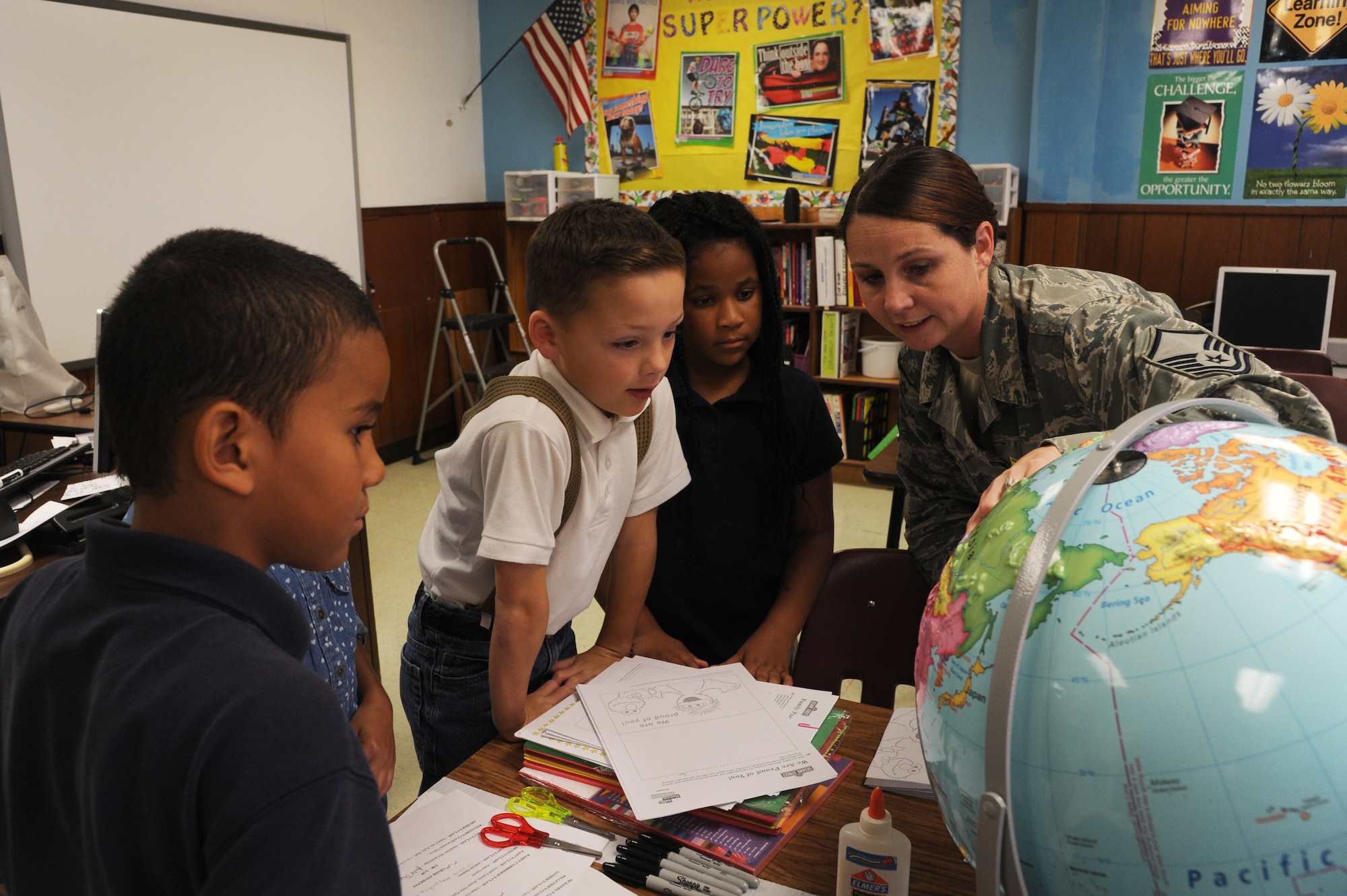 Master Sgt. Kimberly Euton, 19th Force Support Squadron readiness noncommissioned officer in charge, asks a group of students where their parents are deployed Oct. 30, 2014, at Little Rock Air Force Base, Ark. Euton shows children where their parents are deployed to help provide better a perspective to the children. (U.S. Air Force photo by Airman 1st Class Mercedes Muro) 