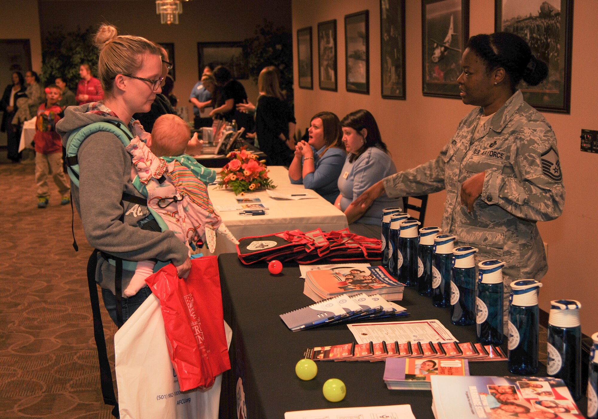 Master Sgt. Tanjanika Smith, 19th Comptroller Squadron financial management analysis flight chief, speaks to the wife and child of a deployed Airman Nov. 4, 2014, at Little Rock Air Force Base, Ark. Smith attended the Deployed Family Dinner to inform families of resilience training opportunities. (U.S. Air Force photo by Airman 1st Class Harry Brexel)