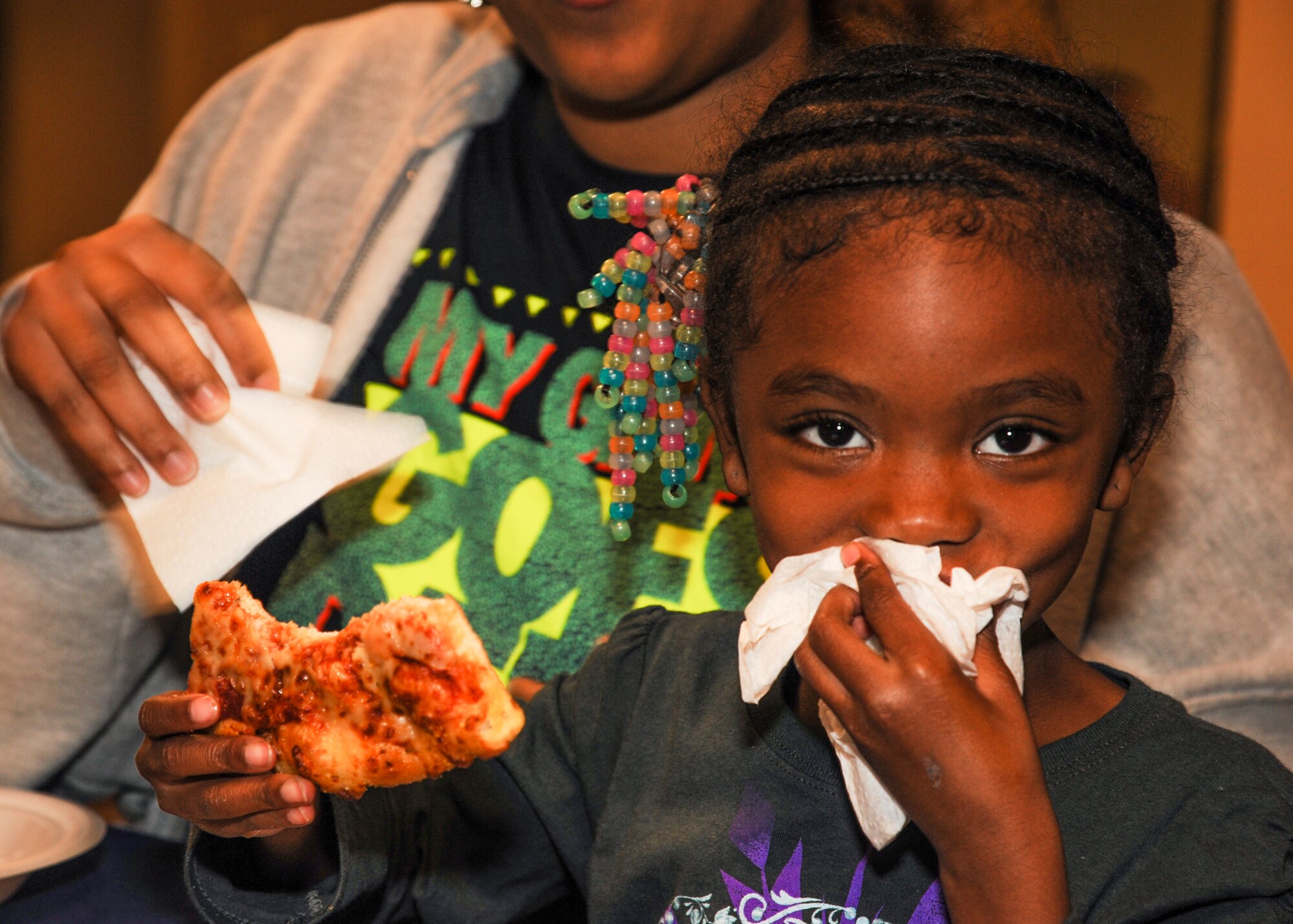 Aniya enjoys pizza during the Deployed Family Dinner Nov. 4, 2014, at Little Rock Air Force Base, Ark. The event is held by the base chapel and unites families who are separated from deployed family members. (U.S. Air Force photo by Airman 1st Class Harry Brexel)