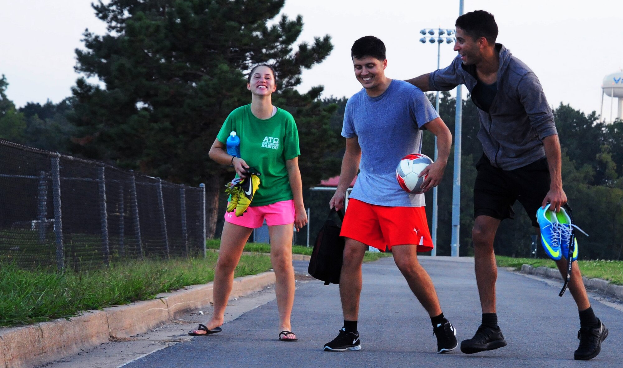 Airman 1st Class Emily Jordan, Staff Sgt. Alan Esqueda, and Senior Airman Carlos Desio, all members of the Sporting Whiteman varsity soccer team, share a laugh after practicing at Whiteman Air Force Base, Sept. 20, 2014. Sporting Whiteman routinely plays competitively against various semi-pro and collegiate teams in the region. (U.S. Air Force photo by Staff Sgt. Nick Wilson/Released)