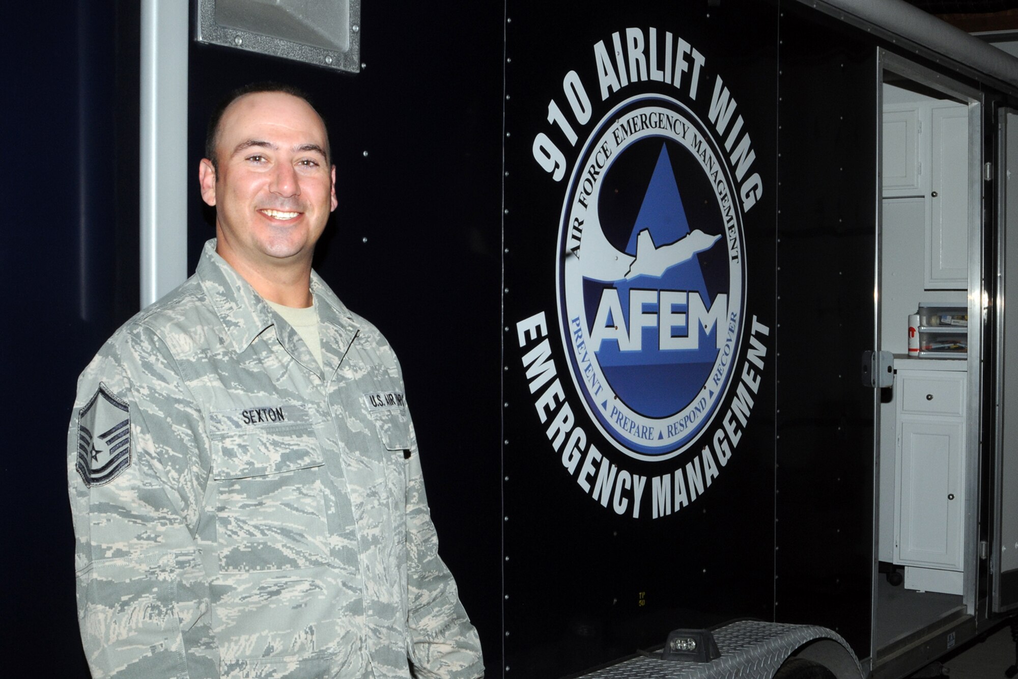 Air Force Reserve Master Sgt. Charles Sexton, 910th Civil Engineer Squadron Noncommissioned Officer in Charge of training and logistics for the Emergency Management Flight, stands in front of the flight’s Emergency Operations Center (EOC) here, Nov. 2, 2014. Sexton was recently named the Air Force Reserve Command (AFRC) Emergency Manager (EM) of the Year for 2014. His design and upgrade communications for the Mobile EOC were one of many major accomplishments qualifying him to win the award. (U.S. Air Force photo/Tech. Sgt. Rick Lisum)