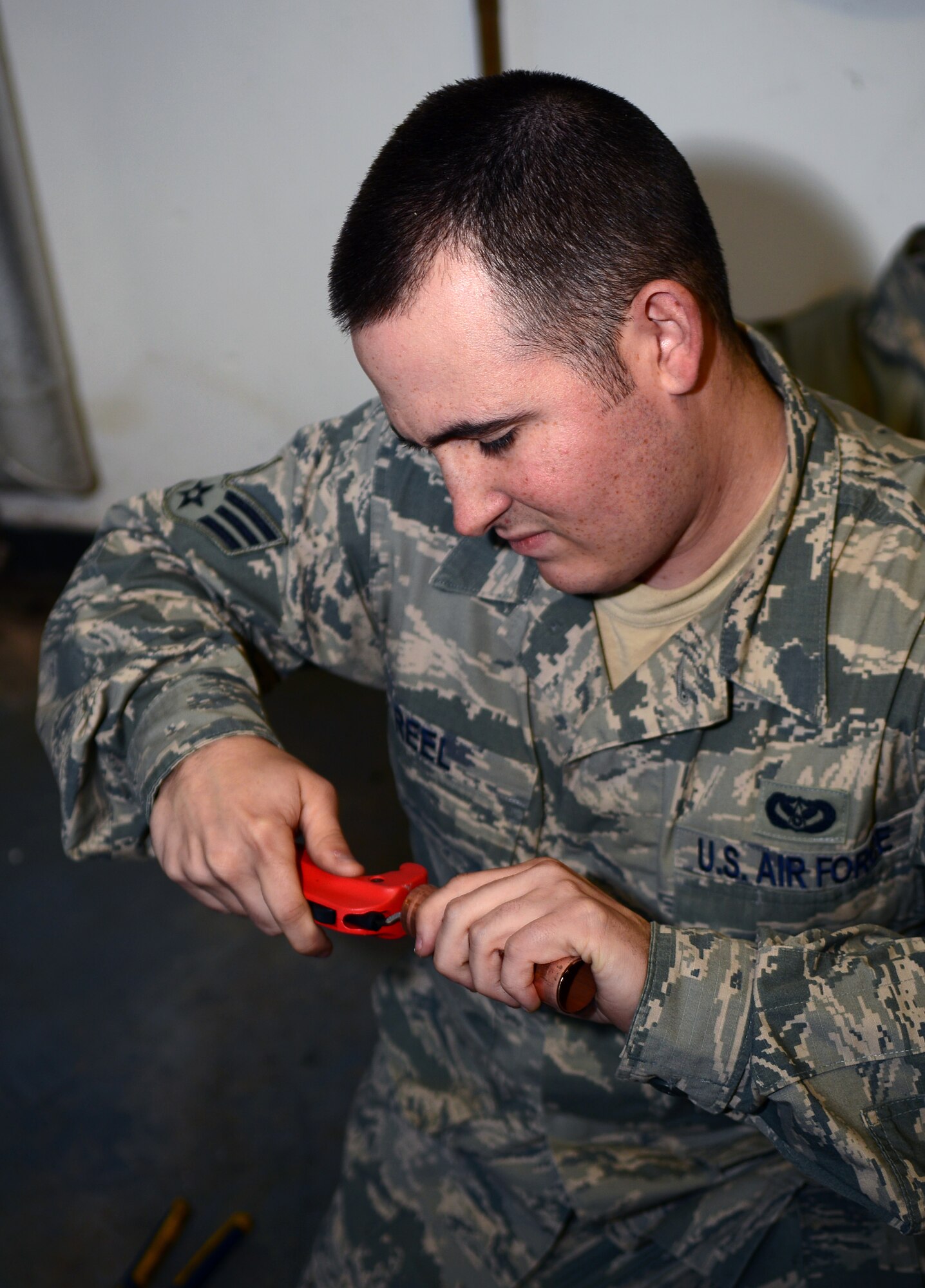 U.S. Air Force Senior Airman Christopher Reel, 100th Civil Engineer Squadron Heating Ventilation and Air Conditioning/Refrigeration journeyman from Owasso, Okla., prepares the end of a new pipe prior to being installed Nov. 5, 2014, on RAF Mildenhall, England. Reel replaced a leaking old pipe restoring hot water to Dorm 215 residents. (U.S. Air Force photo by Airman 1st Class Jonathan Light/Released)