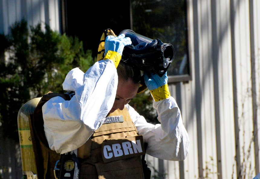 Staff Sgt. Elizabeth McCulley, 307th Bomb Wing emergency manager, removes her equipment for decontamination on Barksdale Air Force Base, La., Oct. 29, 2014. Equipment is decontaminated in order to keep harmful hazards away from safe areas. (U.S. Air Force photo/Airman 1st Class Mozer O. Da Cunha)