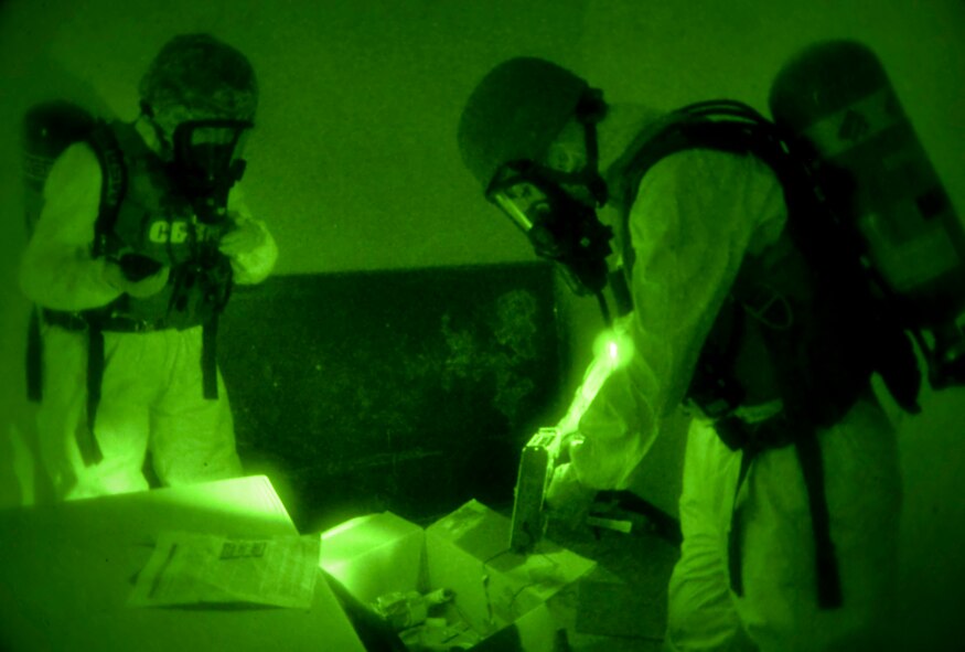 Staff Sgt. Elizabeth McCulley, 307th Bomb Wing emergency manager and Airman 1st Class Victoria Hammond, 2nd Civil Engineer Squadron emergency manager specialist, inspect a biological dispersal device during an exercise on Barksdale Air Force Base, La., Oct. 29, 2014. Emergency management specialists inspect devices for traces of radiological and biological hazards in order to properly identify the threat. (U.S. Air Force photo/Airman 1st Class Mozer O. Da Cunha)