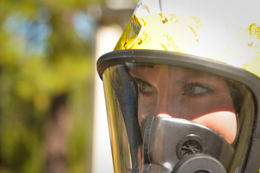 Staff Sgt. Elizabeth McCulley, 307th Bomb Wing emergency manager, visually inspects an exercise scene on Barksdale Air Force Base, La., Oct. 29, 2014. Fire-Hawk masks provide the wearer with a supply of clean oxygen while keeping harmful vapors out. (U.S. Air Force photo/Airman 1st Class Mozer O. Da Cunha)