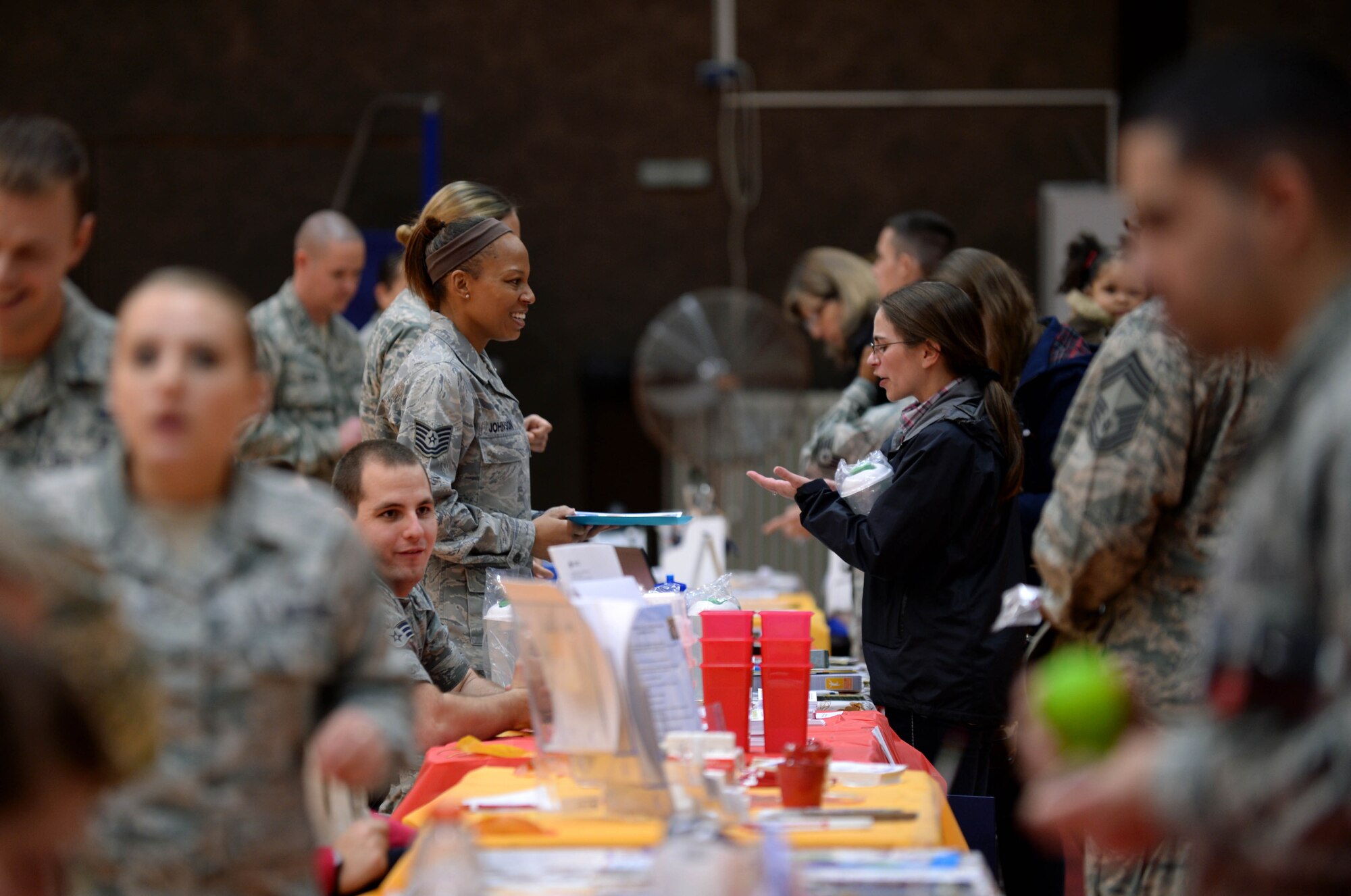 U.S. Air Force Tech. Sgt. Ann Johnson, 52nd Medical Operations Squadron’s Pediatrics Clinic medical technician from Musella, Georgia, center left, provides free information and health checks to a member of the  Spangdahlem community during the 2014 Fall Harvest Health Fair at the Skelton Memorial Fitness Center at Spangdahlem Air Base, Germany, Nov. 5, 2014. More than 30 base agencies provided information and promoted health. (U.S. Air Force photo by Airman 1st Class Timothy Kim/Released)