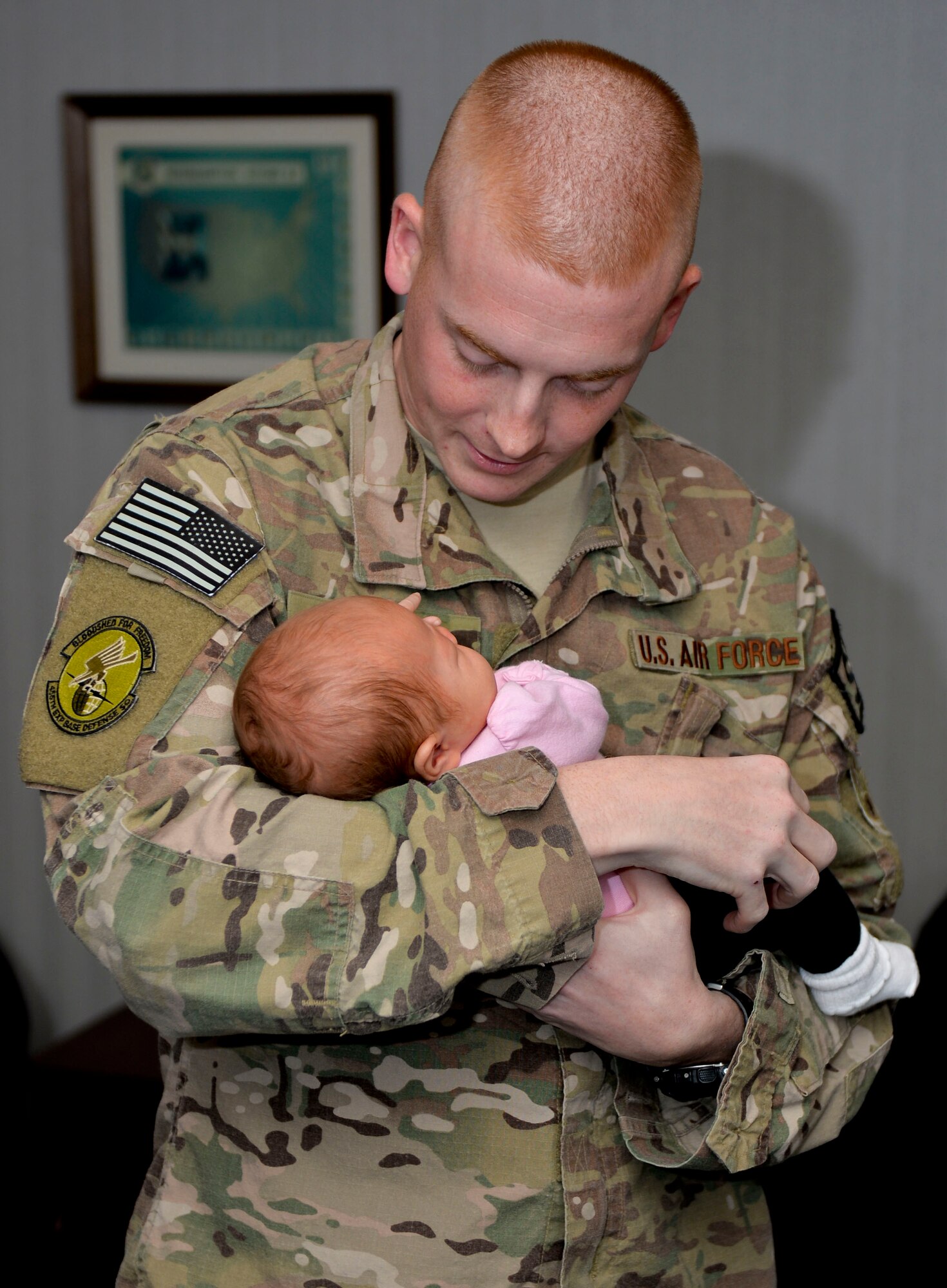 Staff Sgt. Caleb Gore, 2nd Security Forces Squadron desk sergeant, holds his daughter during a welcome home breakfast on Barksdale Air Force Base, La., Nov. 5, 2014. Gore arrived from a deployment to Bagram Airfield, Afghanistan where his team provided flightline and perimeter security for the base. (U.S. Air Force photo/Airman 1st Class Mozer O. Da Cunha)