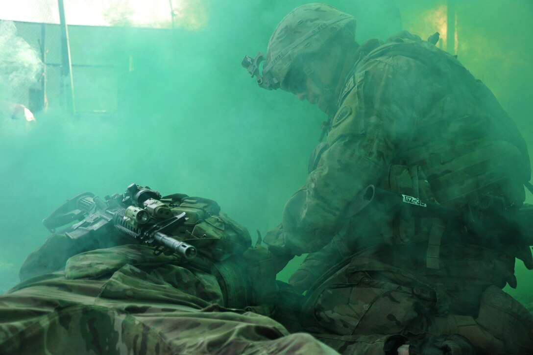 U.S. Army Spc. Guillermo D. Carias, right, places a tourniquet on the left arm of a fellow soldier during a training exercise in Kabul, Afghanistan, Oct. 24, 2014. Carias is a driver assigned to the Oregon Army National Guard's Company A, 2nd Battalion, 162nd Infantry, 41st Infantry Brigade Combat Team.