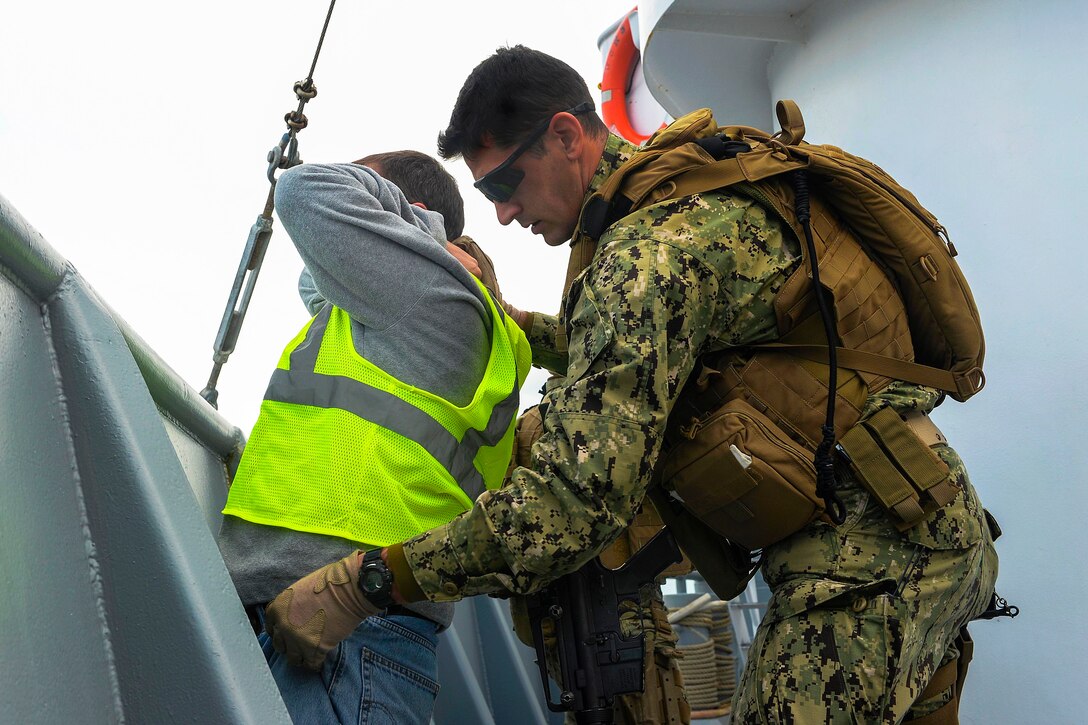Navy Lt. j.g. Kristopher Devisser, right, searches a crew member of the training boat USNS Hunter during the Bold Alligator exercise in Morehead City, N.C., Nov. 2, 2014. Devisser is assigned to Coastal Riverine Squadron 4.