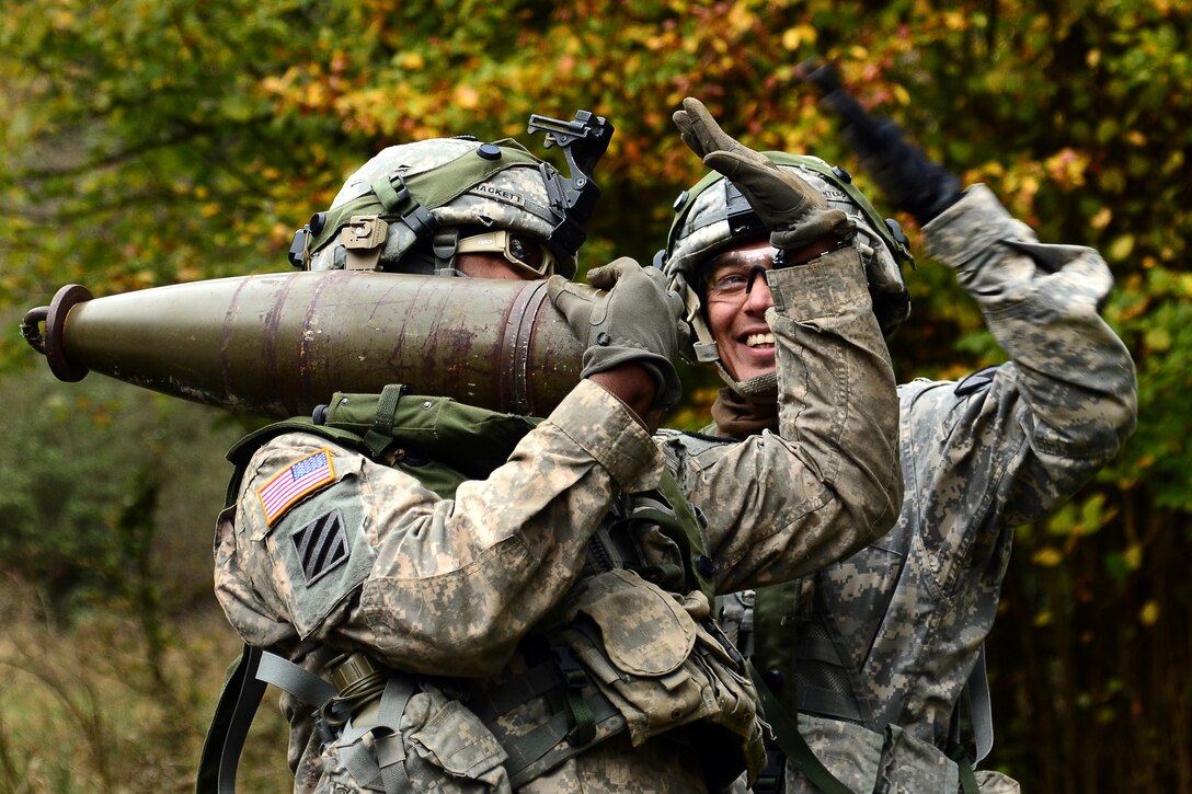 U.S. soldiers high-five one another while carrying a 155 mm round during the Combined Resolve III exercise on Hohenfels Training Area, Germany, Oct. 29, 2014.