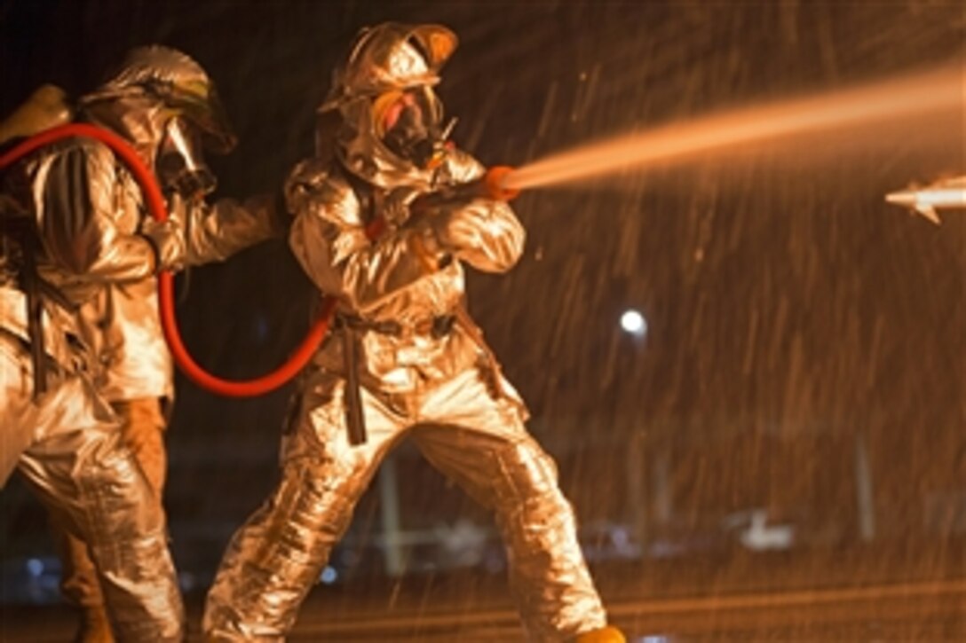 Marines extinguish a blaze from a mobile aircraft firefighting training device on Marine Corps Air Station Kaneohe Bay in Hawaii, Oct. 30, 2014. The Marines are assigned to the Aircraft Rescue and Fire Fighting.