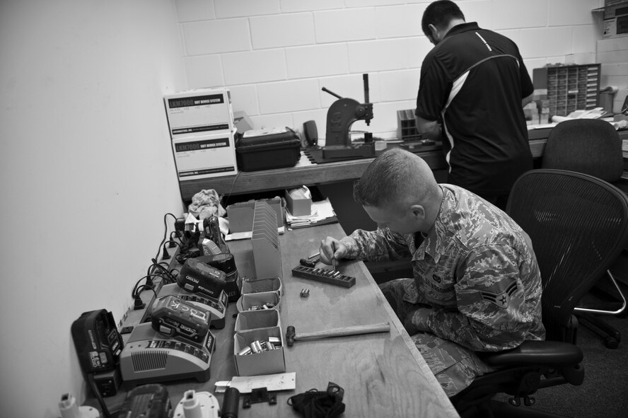 Airman 1st Class Andrew Conner, 1st Special Operations Civil Engineer Squadron structural apprentice, and David Console, 1st SOCES locksmith, work on locks at the locksmith shop on Hurlburt Field, Fla., Nov. 6, 2014. The locksmith shop provides keys to Hurlburt units, and fixes and maintains locks throughout the base. (U.S. Air Force photo/Senior Airman Krystal M. Garrett) 