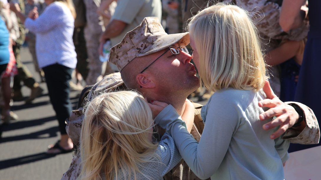 Maj. Jason P. Quinter, future plans officer with I Marine Expeditionary Force and Marine Expeditionary Brigade—Afghanistan, reunites with his children after returning home from a deployment in support of Operation Enduring Freedom, aboard Camp Pendleton, Calif., Nov. 6, 2014. The Marines and Sailors of MEB-A recently completed a transfer of authority with Afghan National Security Forces in Helmand province, marking the end of nine years of Marine operations in the area.