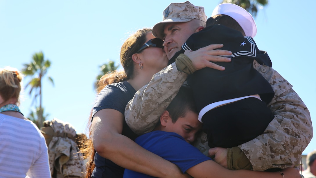 A Sailor with Marine Expeditionary Brigade—Afghanistan embraces his family after returning home from a deployment in support of Operation Enduring Freedom, aboard Camp Pendleton, Calif., Nov. 6, 2014. The Marines and Sailors of MEB-A recently completed a transfer of authority with Afghan National Security Forces in Helmand province, marking the end of nine years of Marine operations in the area.