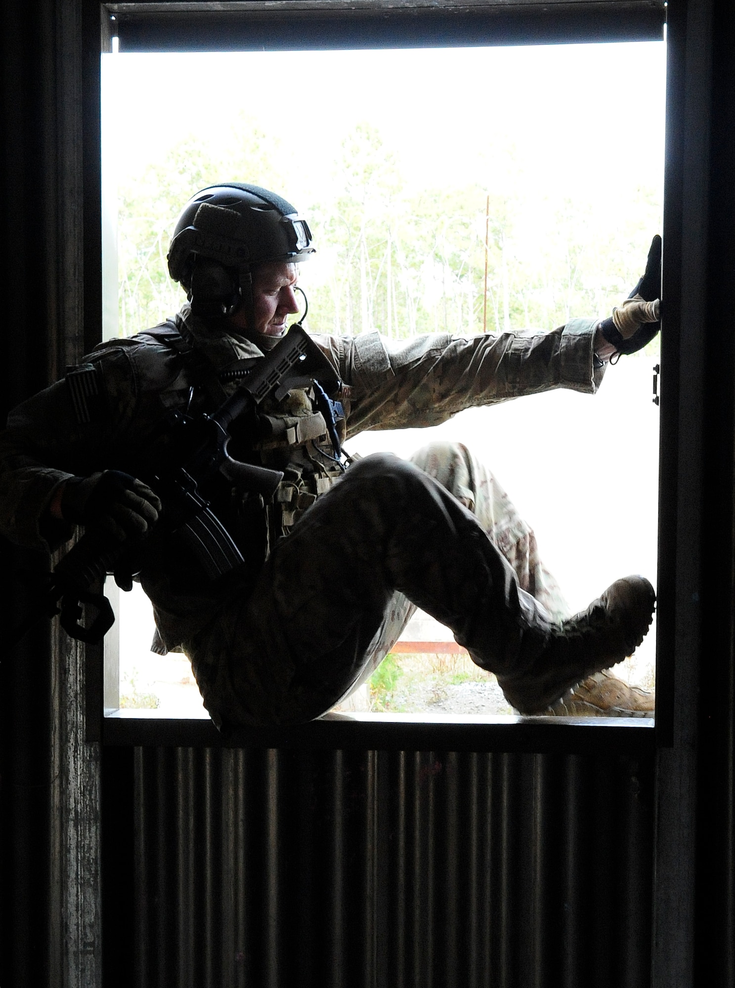 Staff Sgt. Kenneth Paxon, 1st Special Operations Support Squadron Survival, Evasion, Resistance and Escape Specialist, demonstrates how to climb out a window at B-76 Urban Training Area, Eglin Range, Fla., Nov. 5, 2014. It is important for Air Commandos to know how to enter and exit a building using different means, especially in an urban environment. (U.S. Air Force photo/Airman 1st Class Andrea Posey)