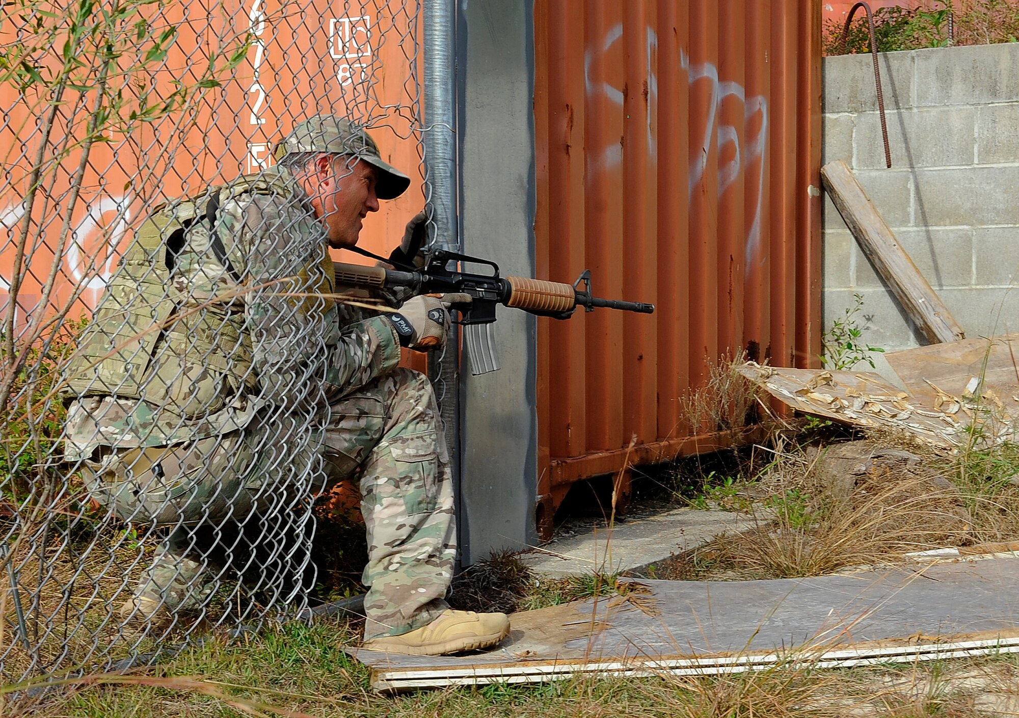Tech. Sgt. Seth Sarrett, 1st Special Operations Support Squadron Survival, Evasion, Resistance and Escape Specialist, demonstrates how to strategically go through a fence at B-76 Urban Training Area, Eglin Range, Fla., Nov. 5, 2014. Air Commandos need to learn how to be creative when going through obstacles in urban environments. (U.S. Air Force photo/Airman 1st Class Andrea Posey)