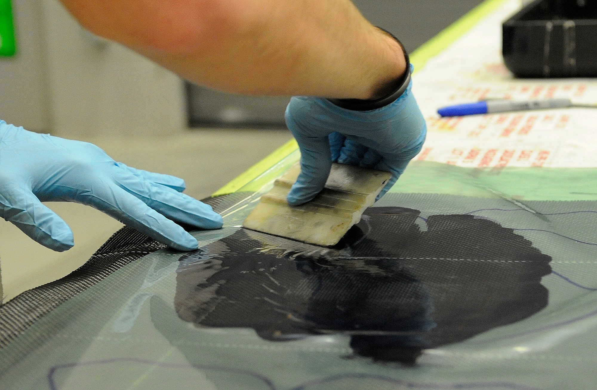 Senior Airman Troy Bannon, 1st Special Operations Equipment Maintenance Squadron aircraft structural maintenance apprentice, flattens a carbon fiber lay-up on Hurlburt Field, Fla., Nov. 3, 2014. After solidifying, the carbon fiber will be used to patch a CV-22 leading edge. (U.S. Air Force photo/Airman 1st Class Andrea Posey)