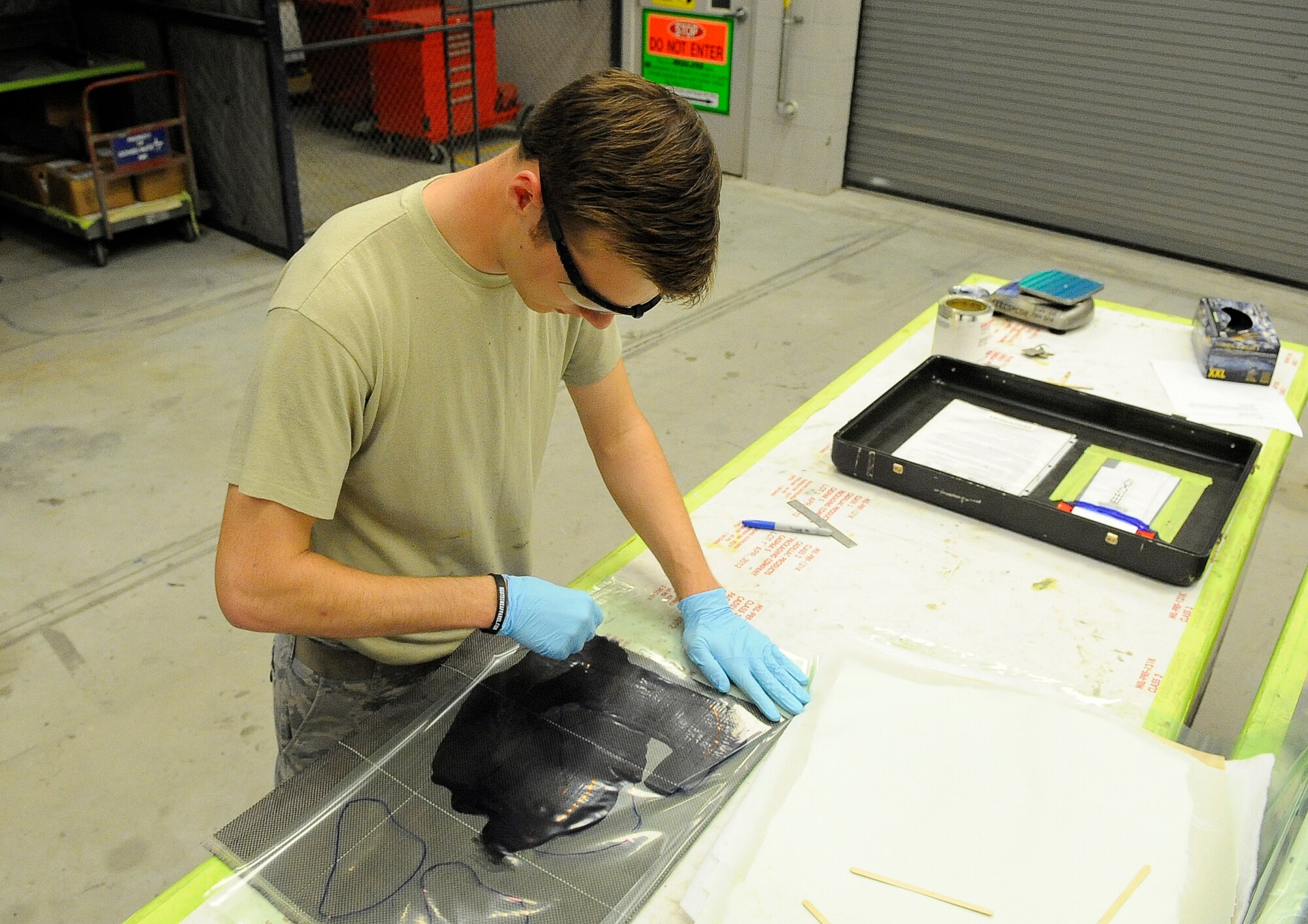 Senior Airman Troy Bannon, 1st Special Operations Equipment Maintenance Squadron aircraft structural maintenance apprentice, flattens a carbon fiber lay-up on Hurlburt Field, Fla., Nov. 3, 2014. After solidifying, the carbon fiber will be used to patch a CV-22 leading edge. (U.S. Air Force photo/Airman 1st Class Andrea Posey)