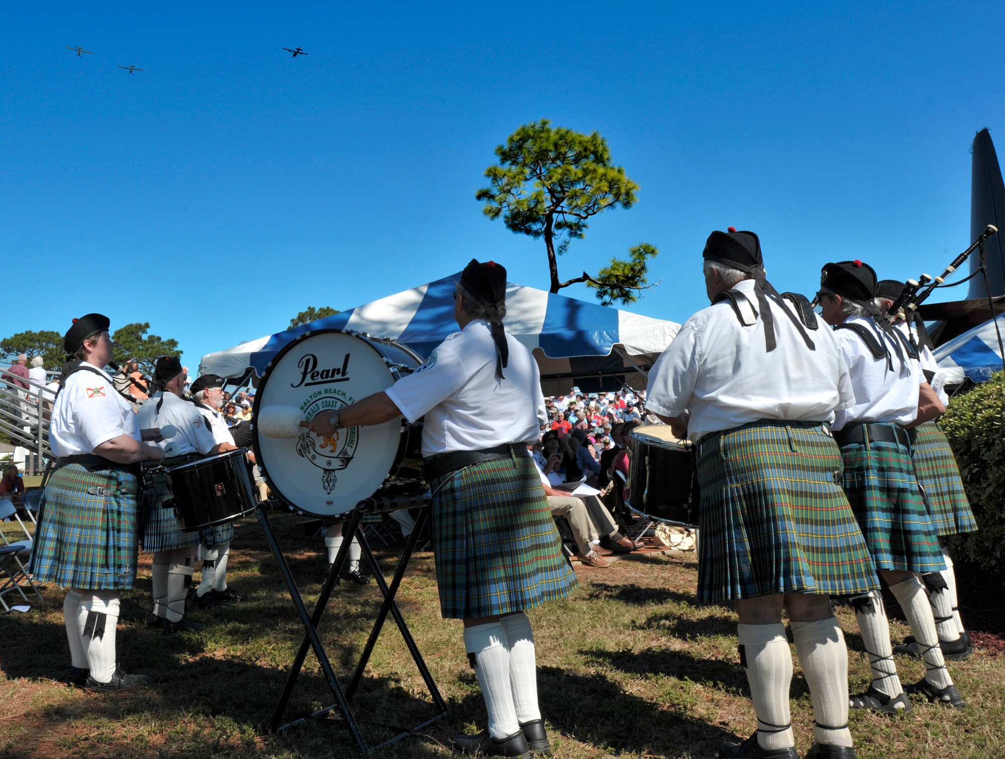 Members of the Emerald Coast Pipers and Drums watch a formation of 0-1 Bird Dogs flyover the Air Park at Hurlburt Field, Fla., Oct. 25, 2014. The group of pipes and drummers played “Amazing Grace” and other symphonies as part of a memorial ceremony for fallen Forward Air Controllers. (U.S. Air Force photo/Senior Airman Kentavist P. Brackin)