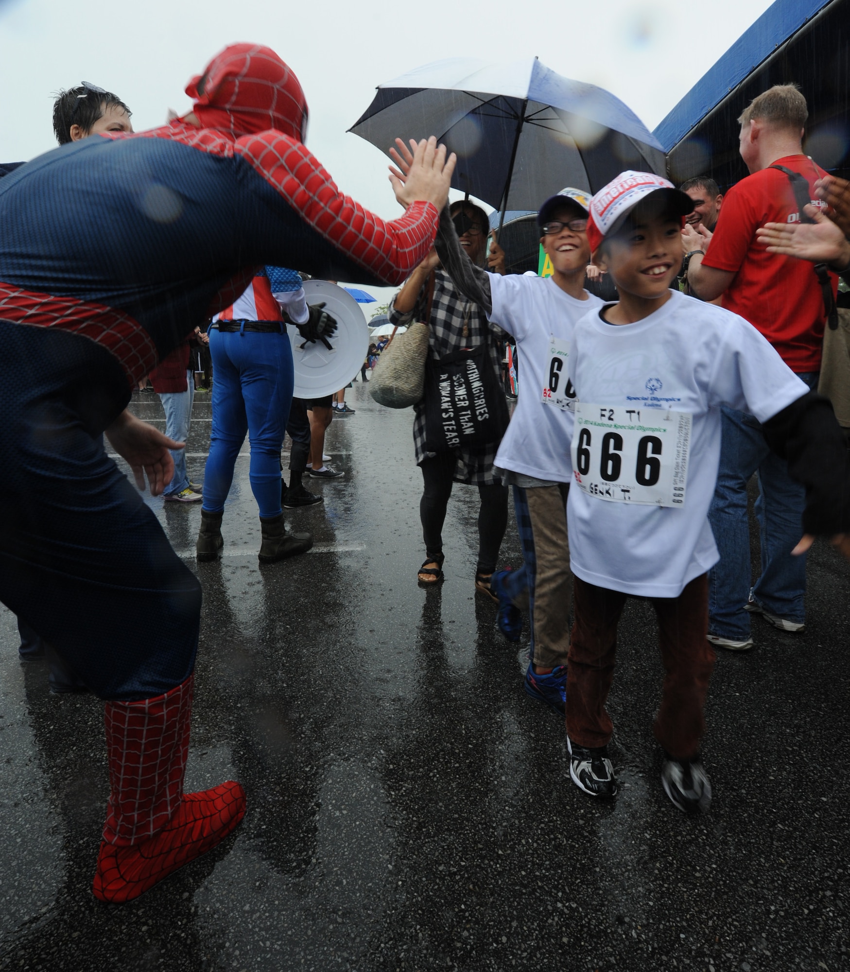 Volunteers in superhero costumes for the Kadena Special Olympics greet Japanese and American athletes as they arrive at the event on Kadena Air Base, Japan, Nov. 8, 2014. KSO is a one-day sporting and entertainment event with approximately 950 special-needs athletes and artists participating in a day of competition, music and special recognition. (U.S. Air Force photo by Airman 1st Class Stephen G. Eigel/Released)