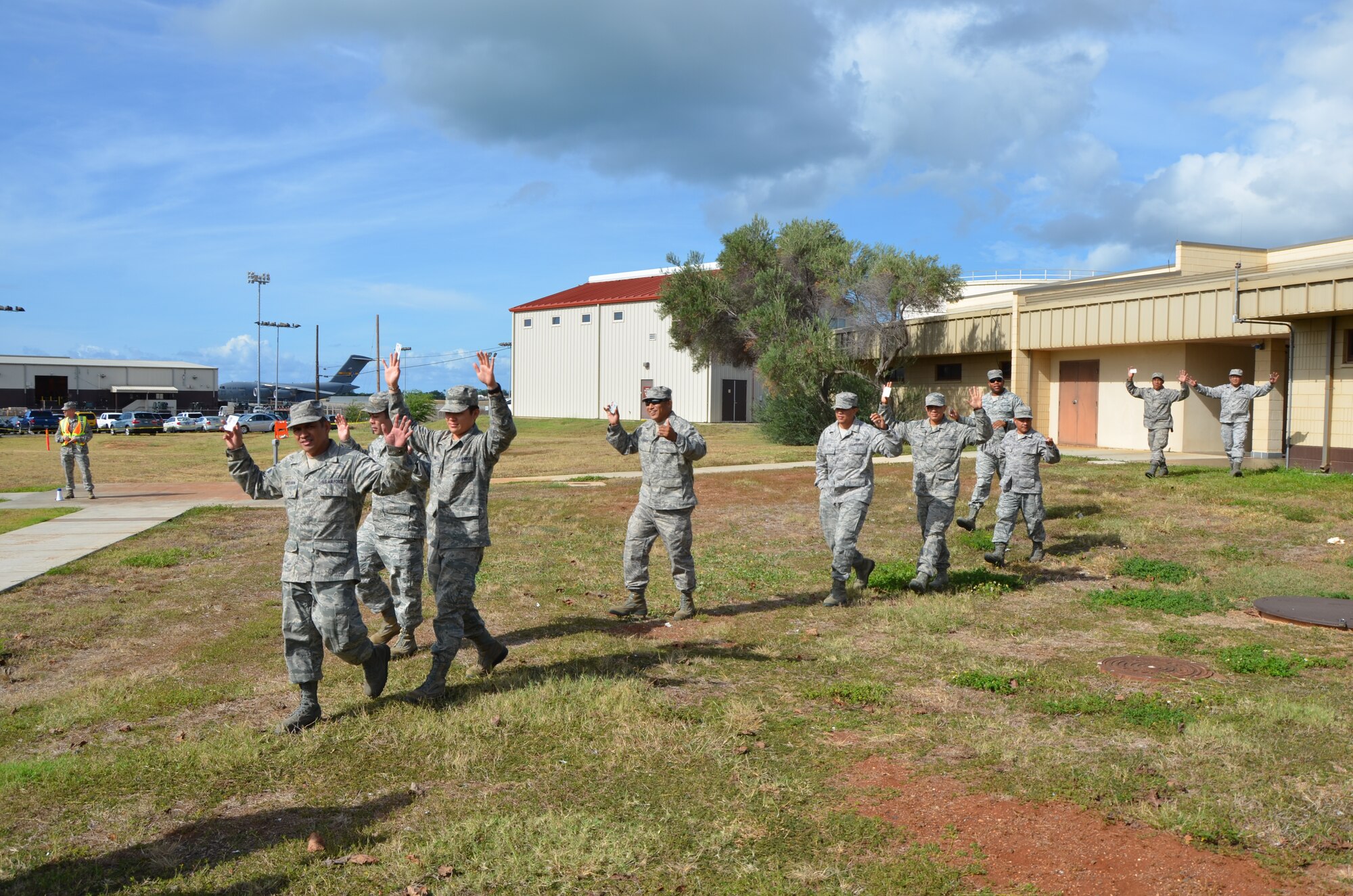 Members of the 48th Aerial Port Squadron exit their building holding their hands in the air during an active shooter exercise the unit staged during a unit training assembly, Joint Base Pearl Harbor-Hickam, Hawaii, Sept. 9, 2014. (U.S. Air Force photo by Tech. Sgt. Phyllis Keith)