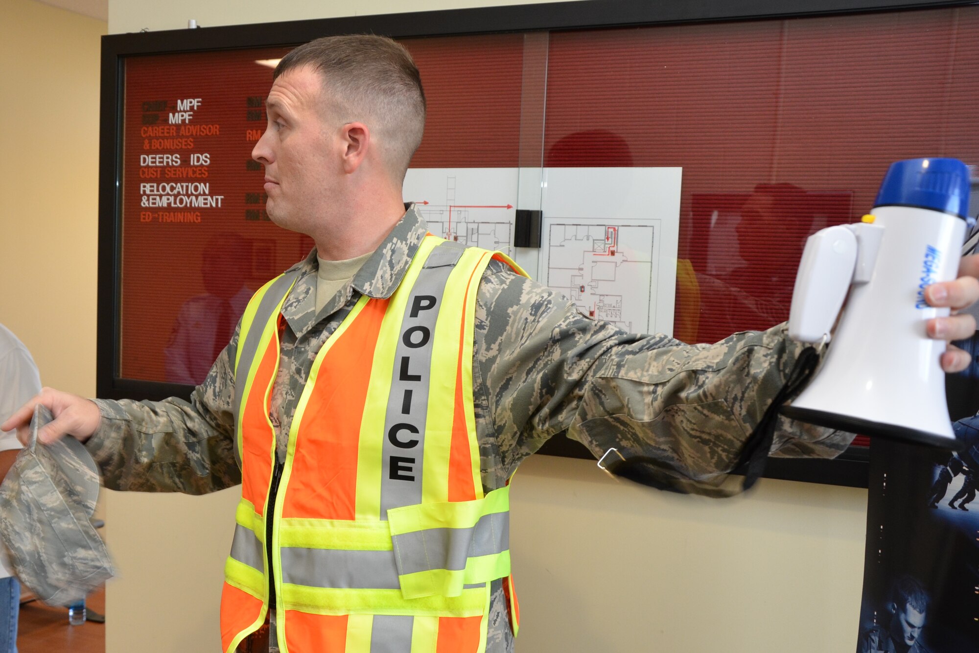 Master Sgt. Jason Boquer-Wintjen, a health services management craftsman with the 624th Aeromedical Staging Squadron, gestures with a baby bullhorn in his left hand as he gives a debrief to the commander and command chief of the 624th Regional Support Group (not pictured) on the results of an active shooter exercise, Joint Base Pearl Harbor-Hickam, Hawaii, Sept. 9, 2014. Boquer-Wintjen called on five Navy reservists who have a combination of civilian and military law enforcement background to help stage the event. (U.S. Air Force photo by Tech. Sgt. Phyllis Keith) 