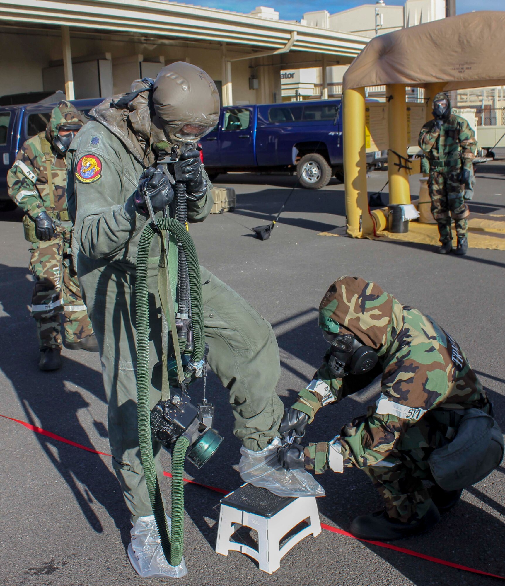 Lt. Col. Gregg Johnson, 535th Airlift Squadron commander, goes through a contamination control area during a chemical, biological, radiological, nuclear and high-yield explosive exercise on Joint Base Pearl Harbor-Hickam, Hawaii, Nov. 7, 2014. The contamination control area allows Airmen exposed to hazards from biological to chemical agents to come "clean" in a controlled environment. (U.S. Air Force photo)
