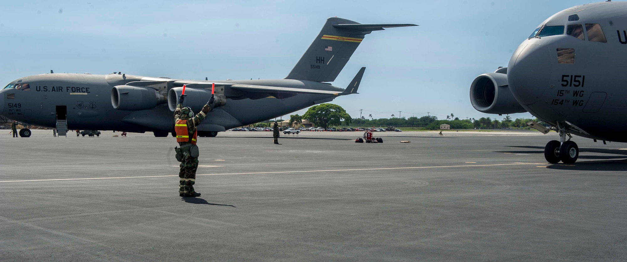 Staff Sgt. Everett Bettencourt, a 15th Aircraft Maintenance Squadron crew chief, marshals in a C-17 Globemaster III during a chemical, biological, radiological, nuclear and high-yield explosive exercise on Joint Base Pearl Harbor-Hickam, Hawaii, Nov. 7, 2014. Throughout the exercise, Airmen were tested on their ability to continue their mission after donning mission oriented protective posture gear, conduct post attack reconnaissance sweeps, react to alarm signals, decontaminate equipment and administer self-aid and buddy care. (U.S. Air Force photo by Tech. Sgt. Terri Paden)