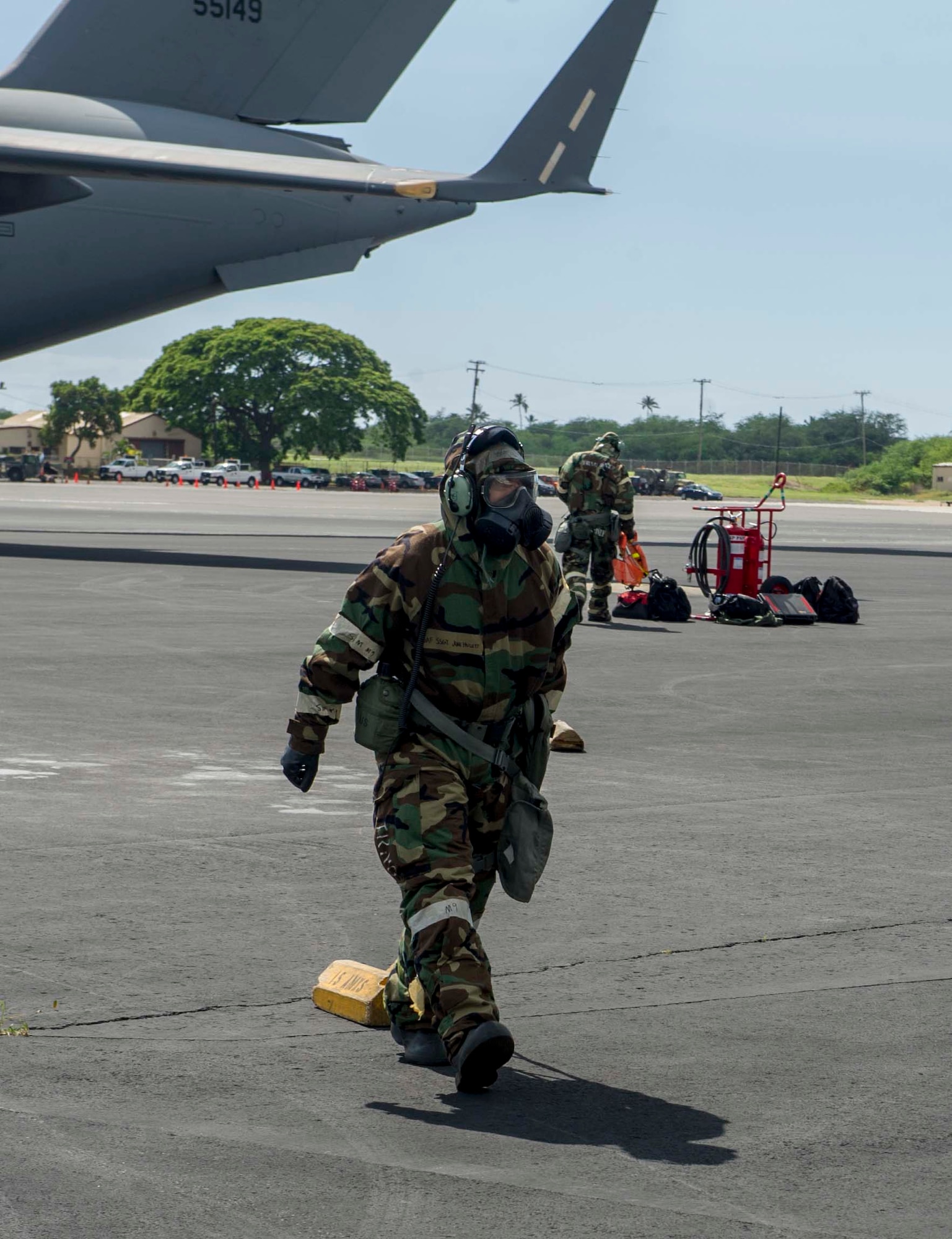 Staff Sgt. Juan Hulett, a 15th Aircraft Maintenance Squadron crew chief, moves an aircraft wheel chalk in preparation for recovering a C-17 Globemaster III during a chemical, biological, radiological, nuclear and high-yield explosive exercise on Joint Base Pearl Harbor-Hickam, Hawaii, Nov. 7, 2014. Throughout the exercise, Airmen were tested on their ability to continue their mission after donning mission oriented protective posture gear, conduct post attack reconnaissance sweeps, react to alarm signals, decontaminate equipment and administer self-aid and buddy care. (U.S. Air Force photo by Tech. Sgt. Terri Paden)