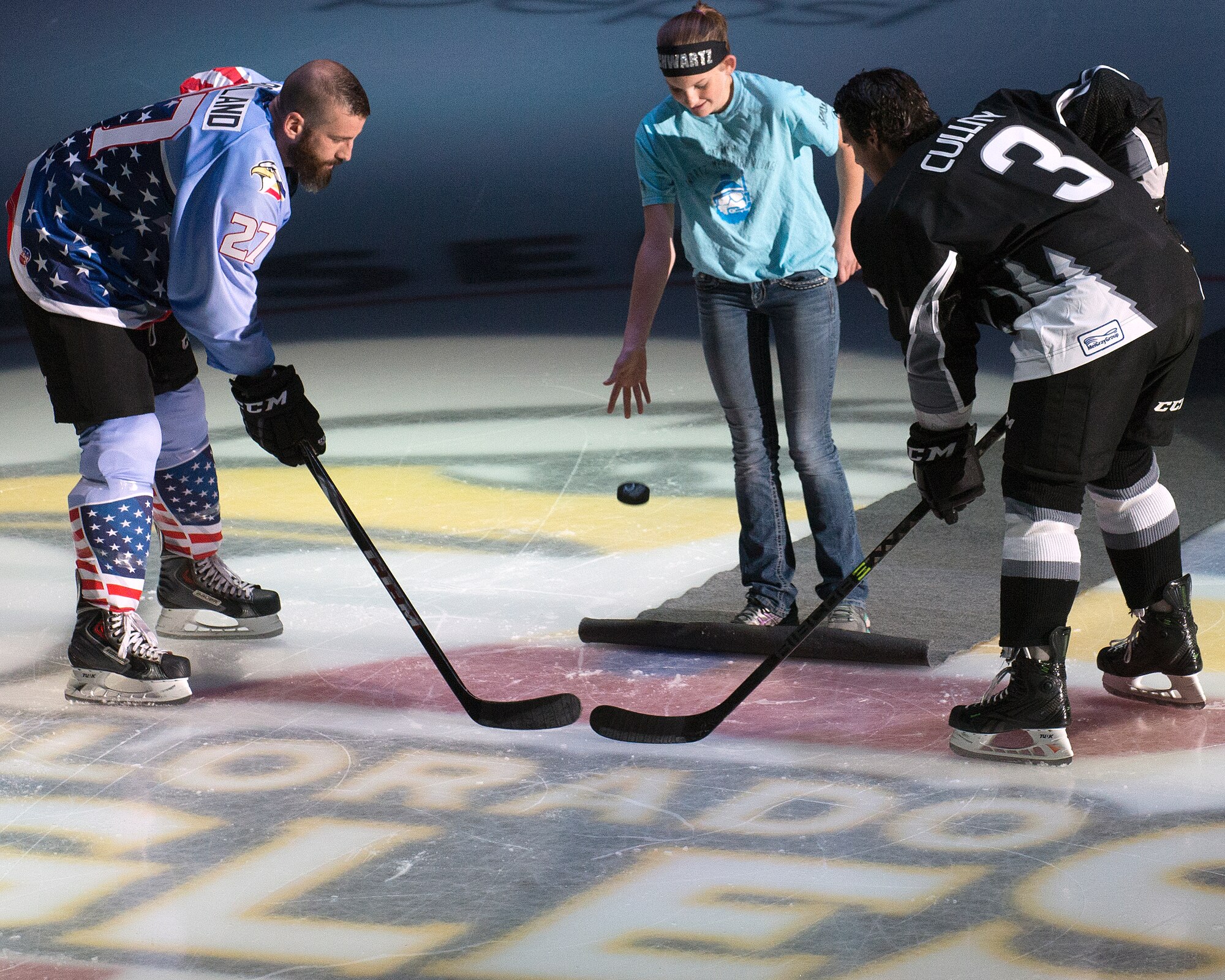 The eldest daughter of the late Tech. Sgt. Matthew Schwartz, an explosive ordnance disposal technician with 90th Civil Engineering Squadron EOD flight who lost his life in 2012, drops the ceremonial game-puck at a Colorado Eagles hockey game, Nov. 5, 2014 in Loveland, Colo. The EOD flight was invited to the game to conduct a demonstration with former Navy SEALs during the first intermission as part of a military appreciation night game. (U.S. Air Force photo by Lan Kim)
