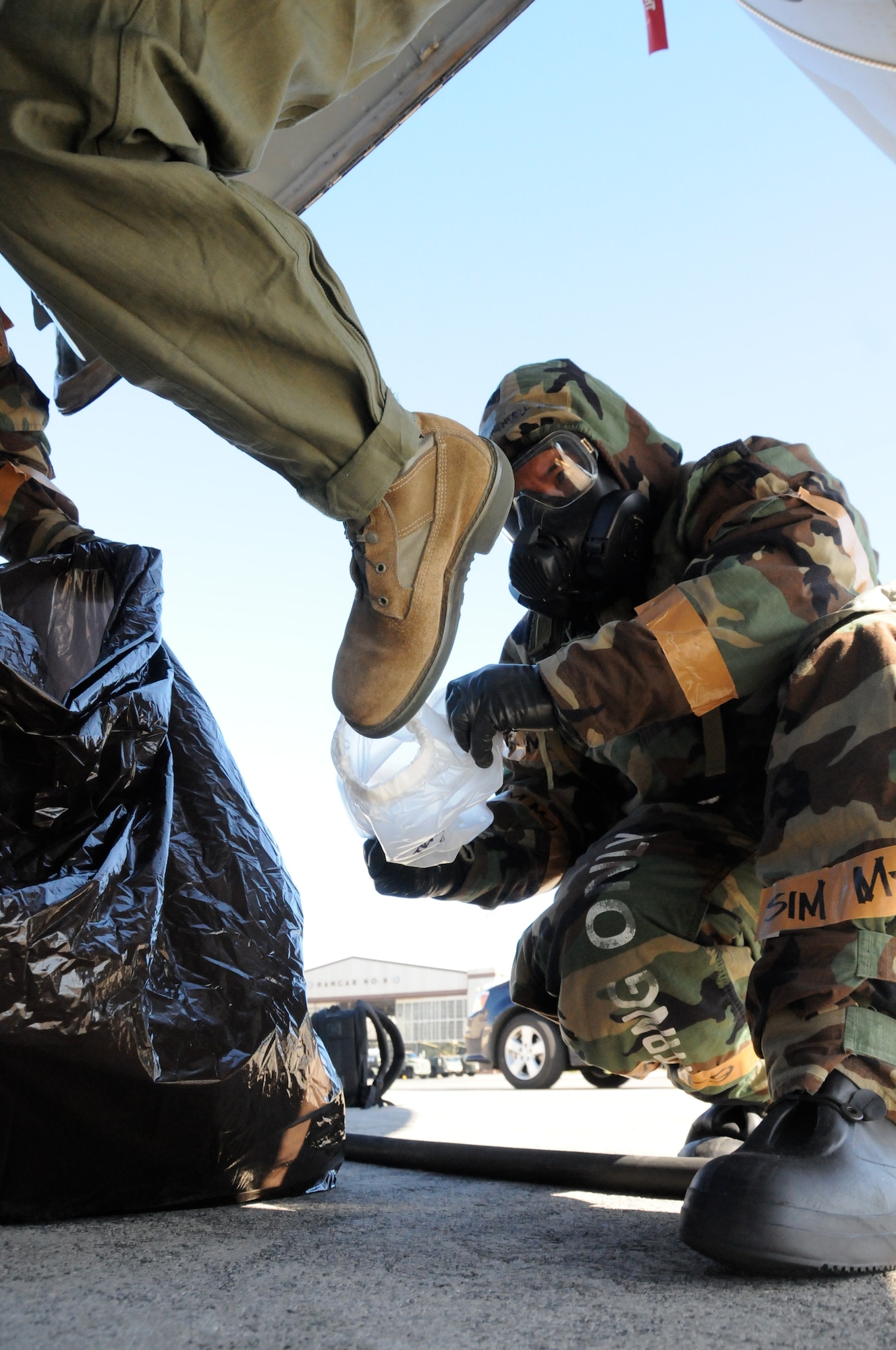 U.S. Air Force Master Sgt. Wendell P. Au, 154th Aircraft Maintenance Squadron (AMXS), Hawaii Air National Guard, removes protective booties from a pilot as he enters a KC-135 Stratotanker during a Chemical, Biological, Radiological, Nuclear and Explosives (CBRNE) Exercise at Joint Base Pearl Harbor Hickam, Hawaii on Nov. 7, 2014. The 203rd ARS and 154th AMXS is undergoing mission readiness evaluation under the Commander's Inspection Program (CCIP). (U.S. Air National Guard photo by Airman 1st Class Robert Cabuco)