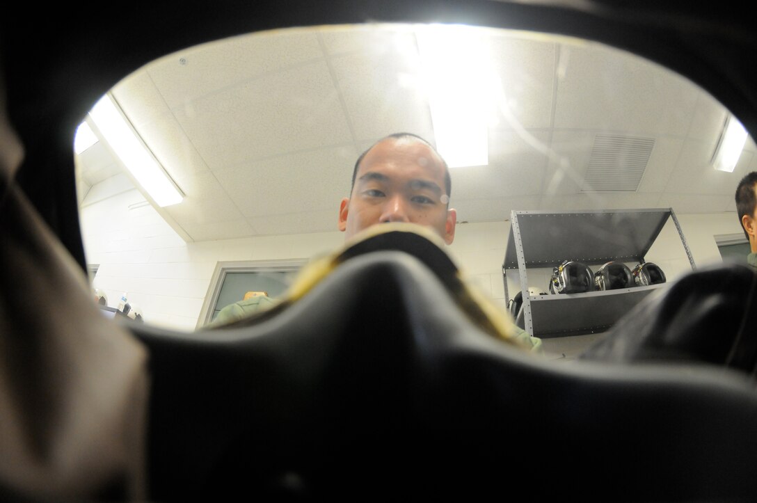U.S. Air Force 1st Lt. Renn D. Nishimoto, a KC-135 pilot for the 203rd Air Refueling Squadron (ARS), Hawaii Air National Guard, examines his gas mask during a Chemical, Biological, Radiological, Nuclear and Explosives (CBRNE) Exercise at Joint Base Pearl Harbor Hickam, Hawaii on Nov. 7, 2014. The 203rd ARS is undergoing mission readiness evaluation under the Commander's Inspection Program (CCIP). (U.S. Air National Guard photo by Airman 1st Class Robert Cabuco)