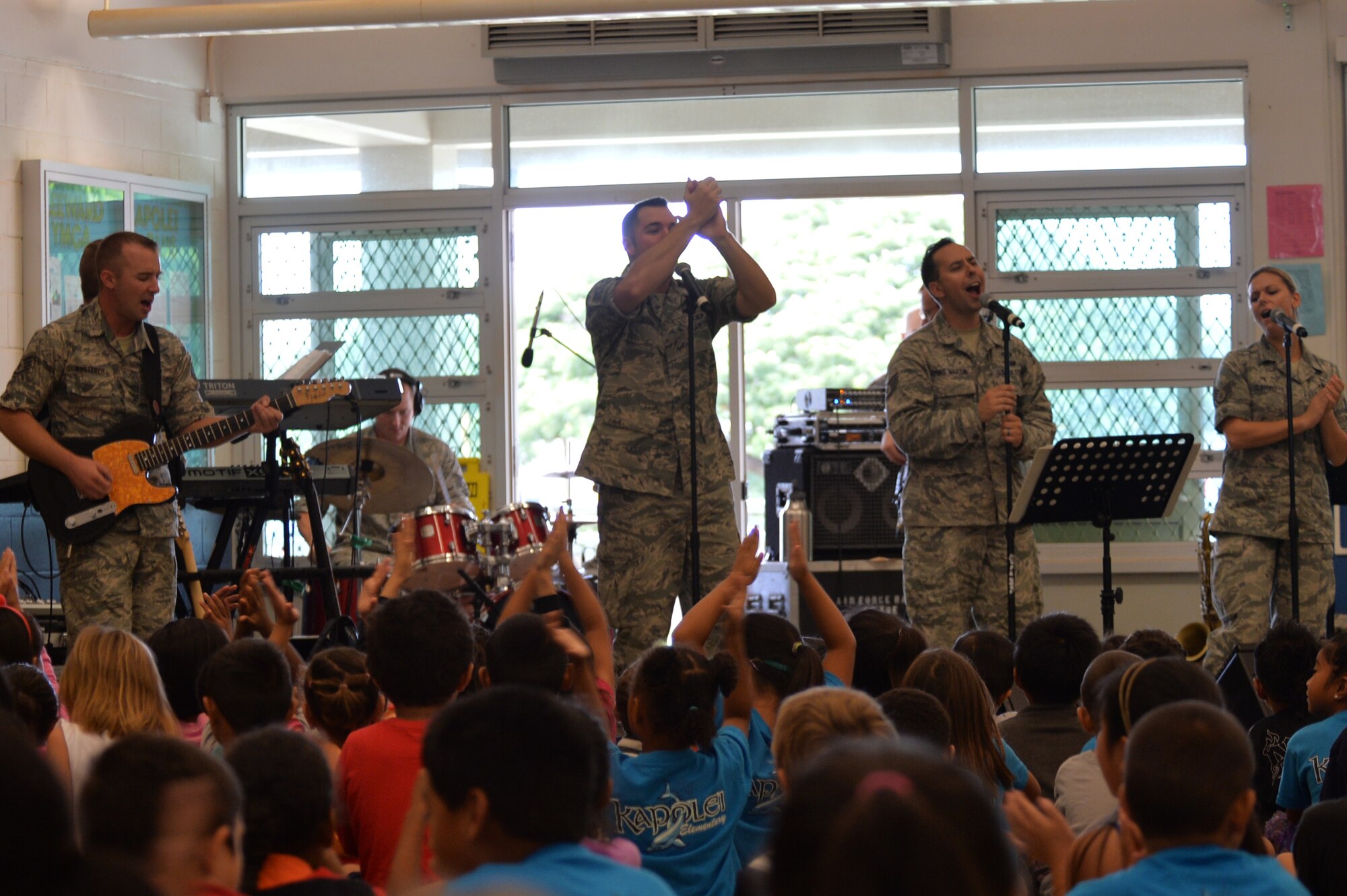 Members of Hana Hou!, the rock band of the U.S. Air Force Band of the Pacific-Hawaii, perform a song for Kapolei Elementary School students and faculty members in Kapolei, Hawaii, Nov. 5, 2014. The performance was part of the school’s observance of National Red Ribbon Week that raises awareness of the effects of drug use. (U.S. Air Force photo by Staff Sgt. Alexander Martinez)  