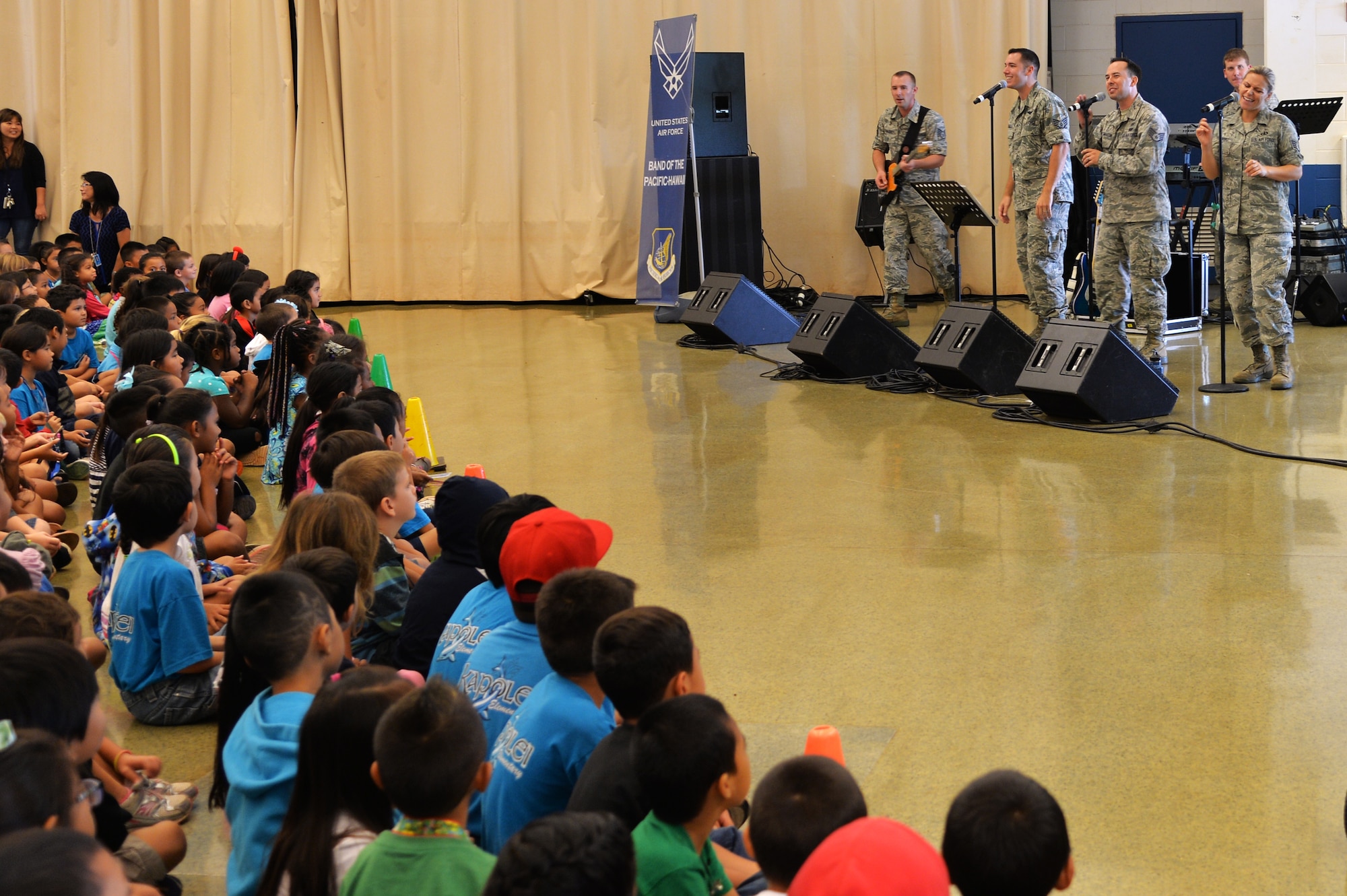 Members of Hana Hou!, the rock band of the U.S. Air Force Band of the Pacific-Hawaii, perform a song for Kapolei Elementary School students and faculty members in Kapolei, Hawaii, Nov. 5, 2014. The performance was part of the school’s observance of National Red Ribbon Week that raises awareness of the effects of drug use. (U.S. Air Force photo by Staff Sgt. Alexander Martinez)  