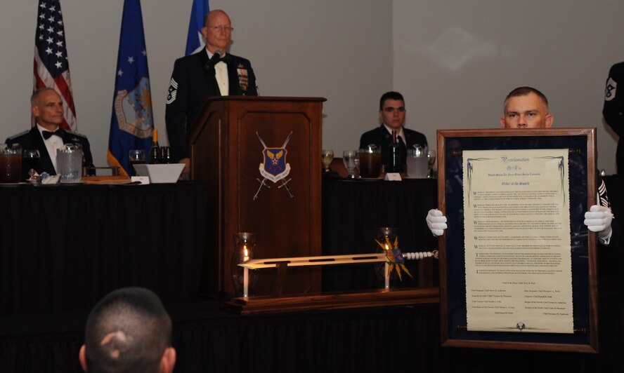 Fulfilling his role as Sergeant-at-Arms, Chief Master Sgt. Thomas Mazzone shows the audience an official proclamation before presenting it to Lt. Gen. James Kowalski, deputy commander of U.S. Strategic Command, at Air Force Global Strike Command’s inaugural Order of the Sword induction ceremony at Barksdale Air Force Base, La., Nov. 6, 2014. Kowalski, who served as commander of AFGSC from Jan. 2011 to Oct. 2013, was chosen by the enlisted corps to become the first inductee of the Order for his significant contributions to the welfare and prestige of the Air Force enlisted force and mission effectiveness. (U.S. Air Force photo by Airman 1st Class Joseph Raatz/Released)