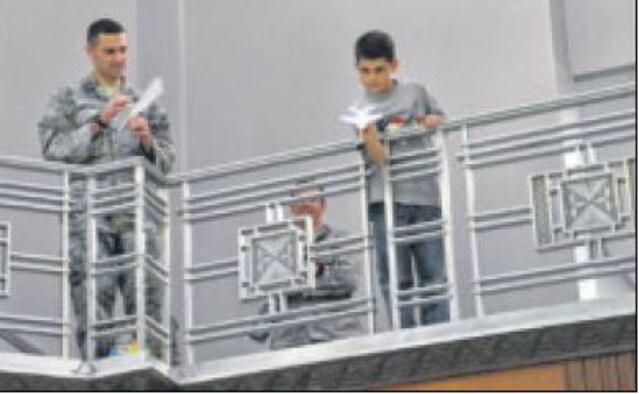 Caleb Ashley, 9, aims for the target in the accuracy competition as Capt. Daniel Luczak prepares his paper airplane for competition. (Air Force photos by Diane Kofoed)