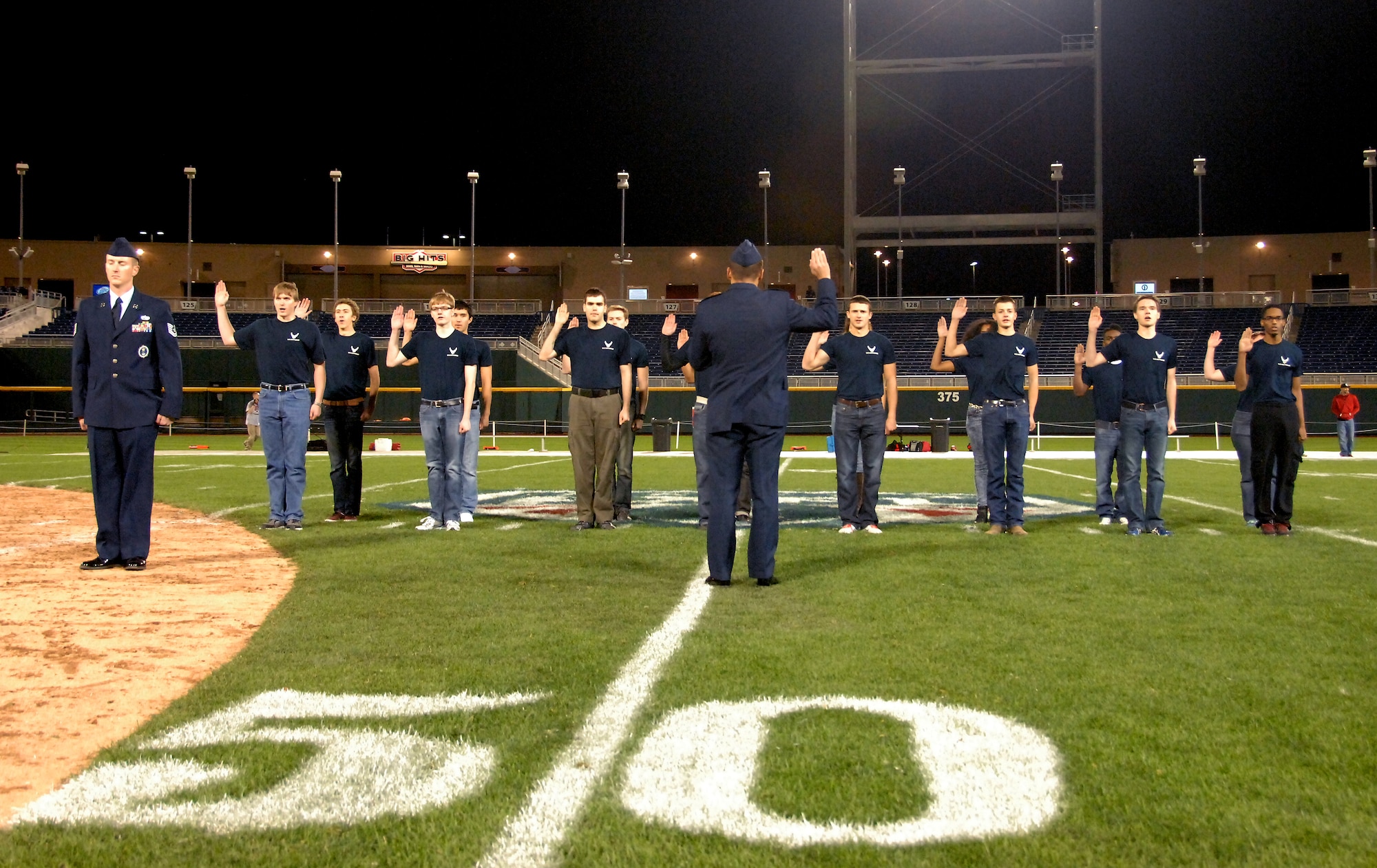 U. S. Air Force Lt. Col. Stephen Phillips (center), commander of the 343rd Recruiting Squadron at Offutt Air Force Base, Nebraska, administers a ceremonial swearing in oath to Air Force recruits during  halftime of an Omaha Mammoths football game held at TD Ameritrade Park in downtown Omaha, Nebraska Nov. 5. The Mammoths organization welcomed military members as part of their Military Appreciation Night. (U. S. Air Force photo by Delanie Stafford)