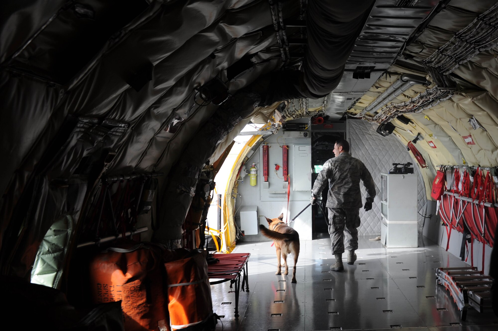 Tech. Sgt. Max Soto, 22nd Security Forces Squadron kennel master, and Iras, Military Working Dog, work together to find drugs that were placed on a KC-135R Stratotanker as part of a training exercise, Nov. 7, at McConnell Air Force Base, Kan. Iras is in the beginning stages of his training and will use these scenarios to learn and perfect his search technique.  (U.S. Air Force photo/Airman 1st Class Tara Fadenrecht)