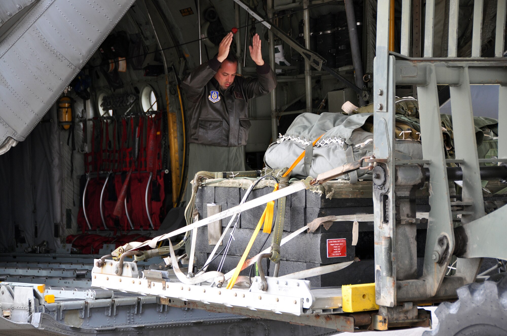 A loadmaster with the 758th Airlift Squadron guides a palletized load onto a heavy equipment platform in the rear of a C-130 on the flight line of Pittsburgh International Airport Air Reserve Station, Nov. 1, 2014. The first portion of the flight generation exercise readied five aircraft simultaneously for flight. (U.S. Air Force photo by Senior Airman Joseph E. Bridge)