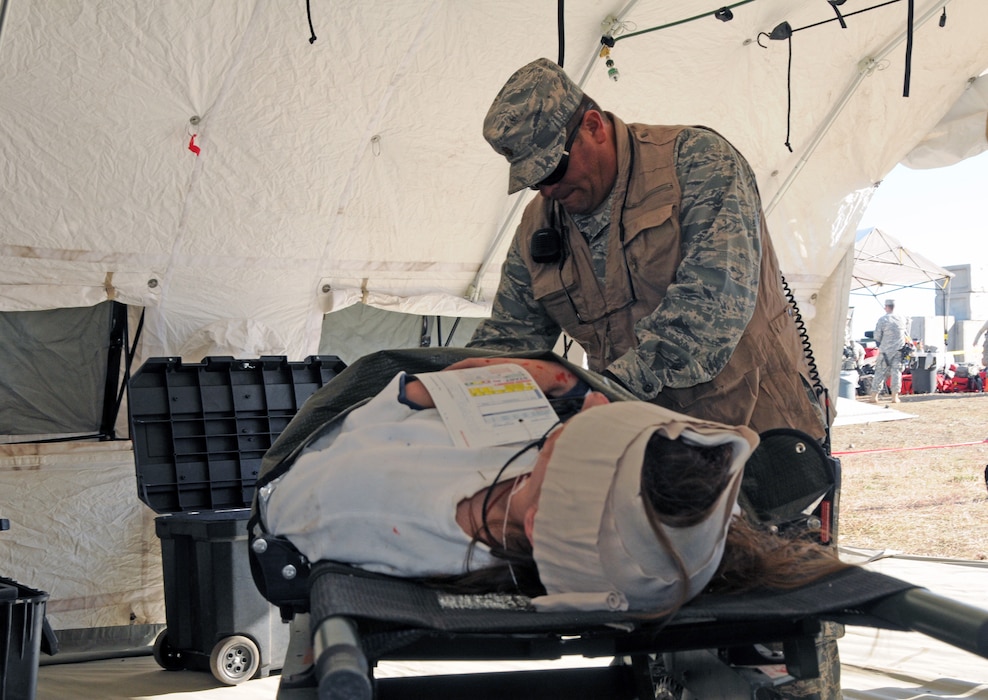 Maj. Todd Bingham, CERFP chief nurse with the 151st Medical Group, treats a mock casualty during Vigilant Guard training at a simulated rubble pile in Magna, Utah on November 4, 2014. (Air National Guard photo by Staff Sgt. Annie Edwards/RELEASED)