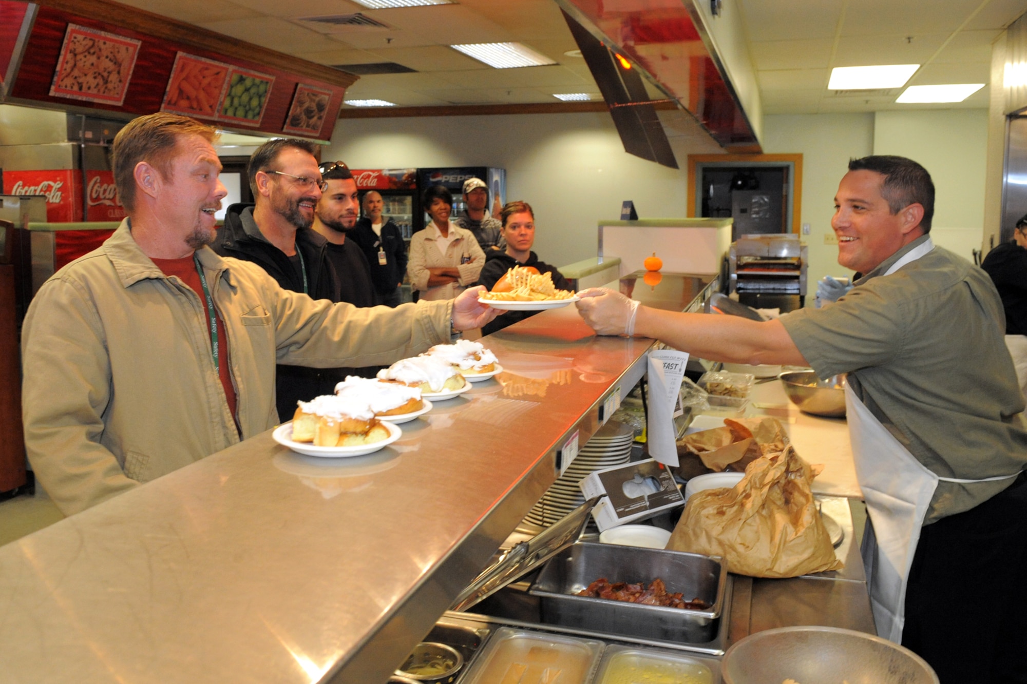 Mr. Pete Virnig serves lunch to Mr. Curt Welter at the new "Skyward Café", bldg 230, Oct 28th, 2014. The old "Crosswinds" base restaurant has been renamed the "Skyward café", under new management of Lancer Hospitality, with a fresh, new approach on the classic café experience. (U.S. Air Force photo by Todd Cromar)