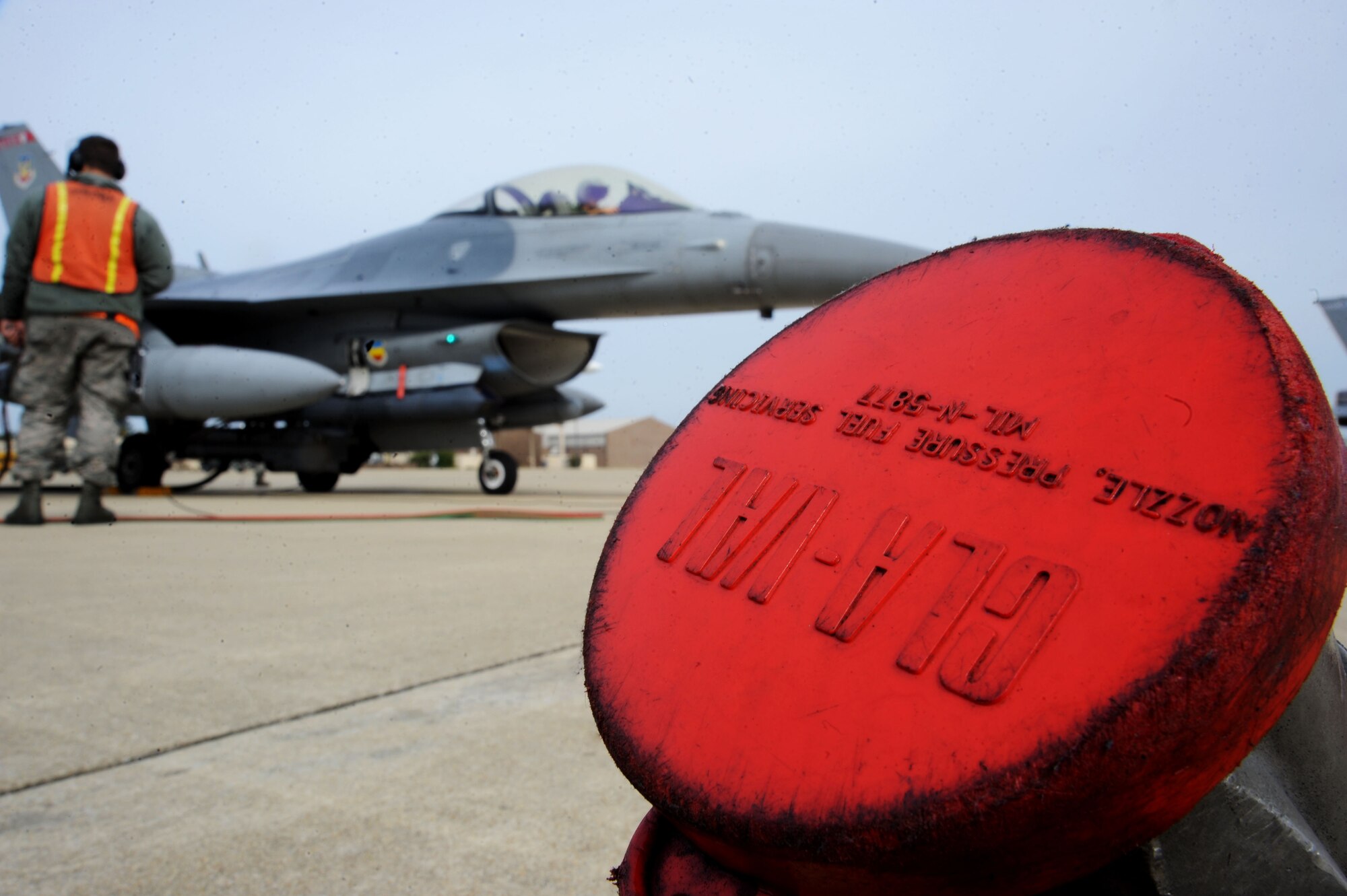 A U.S. Air Force Airman assigned to the 20th Aircraft Maintenance Squadron prepares to marshal a jet after hot pit refueling at Shaw Air Force Base, S.C., Nov. 5, 2014. Hot pits are usually performed in a combat situation to rapidly refuel an aircraft and get them back into the fight. (U.S. Air Force photo by Airman 1st Class Michael Cossaboom/Released)