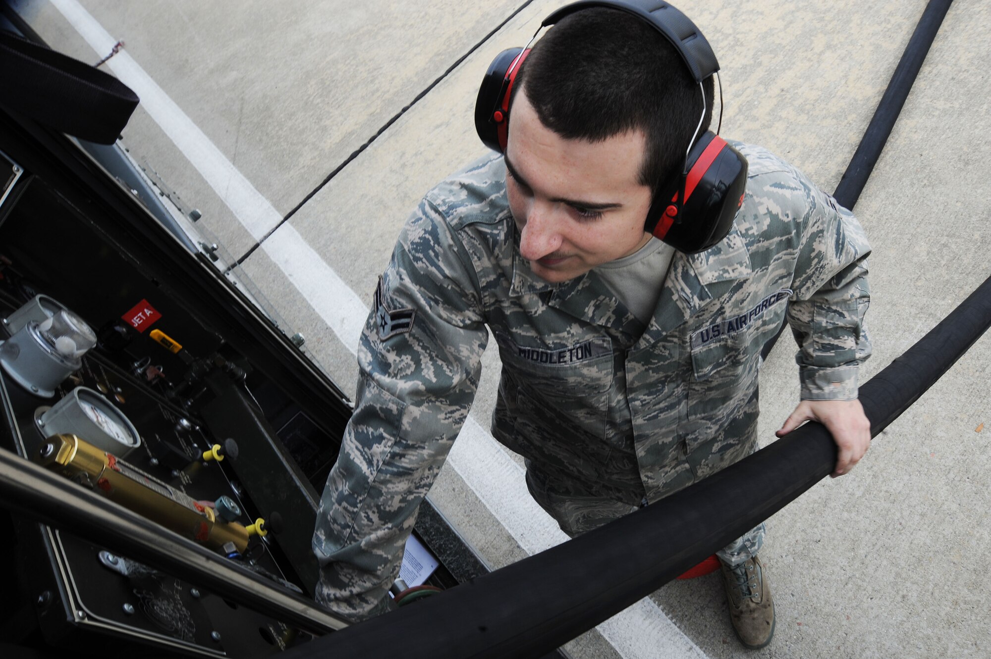 U.S. Air Force Airman 1st Class Daniel Middleton, 20th Logistics Readiness Squadron fuels distribution operator, retracts a fuel hose after hot pit refueling at Shaw Air Force Base, S.C., Nov. 5, 2014. During hot pit refueling, fuels Airmen work with tactical aircraft maintainers to fuel the jet quickly in order to get it back in to the air. (U.S. Air Force photo by Airman 1st Class Michael Cossaboom/Released)