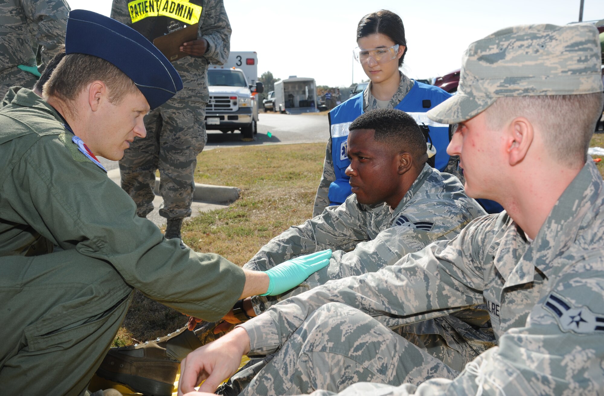 Capt. Chase Rogers, 81st Aerospace Medicine Squadron, with the assistance of Airman 1st Class Ionela Wegner, 81st Medical Operations Squadron, administers medical triage to Senior Airman Alfred Smith, 403rd Logistics Readiness Squadron, and Airman 1st Class Timmothy Allred, 81st Contracting Squadron, as they portray “victims” during a hazardous material exercise scenario Nov. 5, 2014, at the Taylor Logistics Center, Keesler Air Force Base, Miss.  The exercise scenario began with an Airman accidentally hitting a 55-gallon drum of sulfuric acid with a forklift and knocking several more drums off of a truck causing the liquid to splash onto other Airmen.  Immediately, the Airmen simulated skin and eye burns from exposure to the agent, while additional Airmen on the loading dock started coughing and experiencing shortness of breath.  (U.S. Air Force photo by Kemberly Groue)