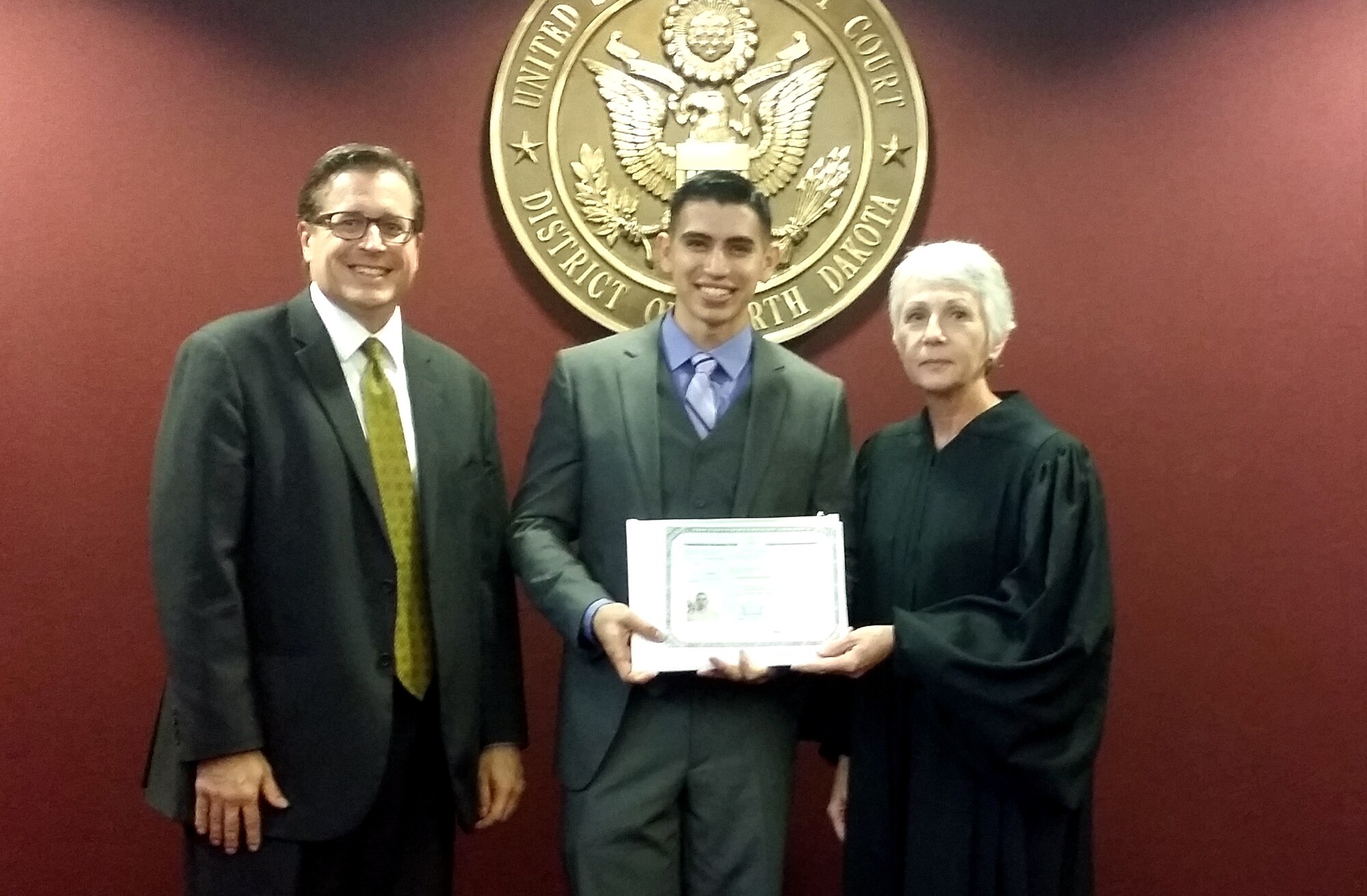 Airman 1st Class Marco Antonio Guerrero Nacif, 319th Civil Engineer Squadron, accepts his certificate of citizenship Oct. 17, 2014, in Fargo, N.D. Guerrero officially obtained his U.S. citizenship after joining the Air Force earlier this year. (Courtesy photo)