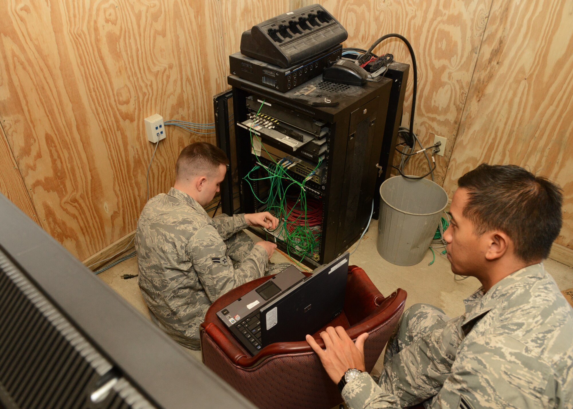U.S. Air Force Airmen from the 633rd Communications Squadron install wiring in the Morale, Welfare and Recreation room at the Langley Transit Center at Langley Air Force Base, Va., Nov. 5, 2014. The transit center features an entertainment facility, known as “the Hub,” that boasts several high-tech entertainment options, including next-generation video gaming consoles, flat-screen televisions and networked computers for use by Service members who recently returned from Ebola response missions in West Africa that are undergoing the Department of Defense-mandated 21-day controlled monitoring period at the center. (U.S. Air Force photo by Staff Sgt. Jason J. Brown/Released)