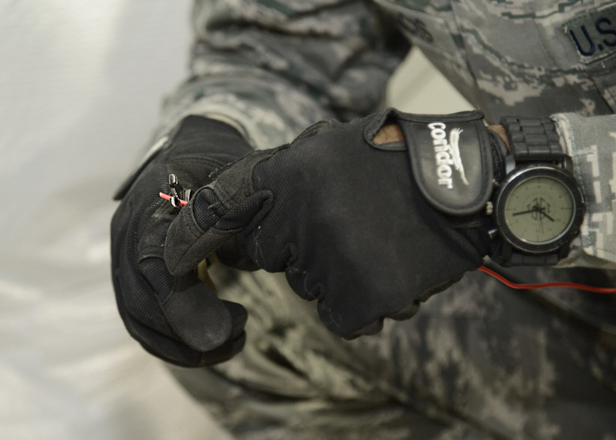 U.S. Air Force Staff Sgt. Mario Francis, 633rd Civil Engineer Squadron electrical systems craftsman, strips wiring while installing a relay module in the Langley Transit Center fitness center at Langley Air Force Base, Va., Nov. 5, 2014. The transit center boasts a variety of recreation options for Service members undergoing the 21-day controlled monitoring period after returning from West Africa, including an entertainment center, fitness center and outdoor recreation facilities. (U.S. Air Force photo by Staff Sgt. Jason J. Brown/Released)