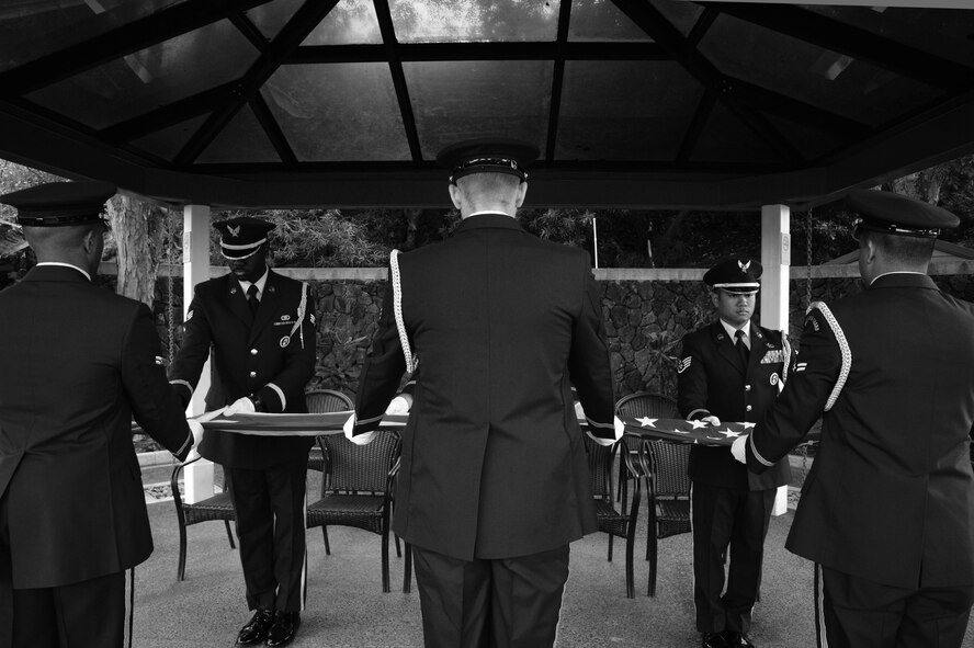 Hickam Honor Guard members unfold a U.S. flag in preparation for the flag to be draped over a casket at the National Memorial Cemetery of the Pacific in Honolulu, Hawaii, Nov. 4, 2014. The Honor Guard members practiced going through a funeral ceremony in order to ensure they execute the actual ceremony with no mistakes. The Hickam Honor Guard is the busiest in the Pacific, and one of the busiest in the Air Force providing the majority of their ceremony support for the Hawaiian Islands. (U.S. Air Force photo by Staff Sgt. Alexander Martinez)